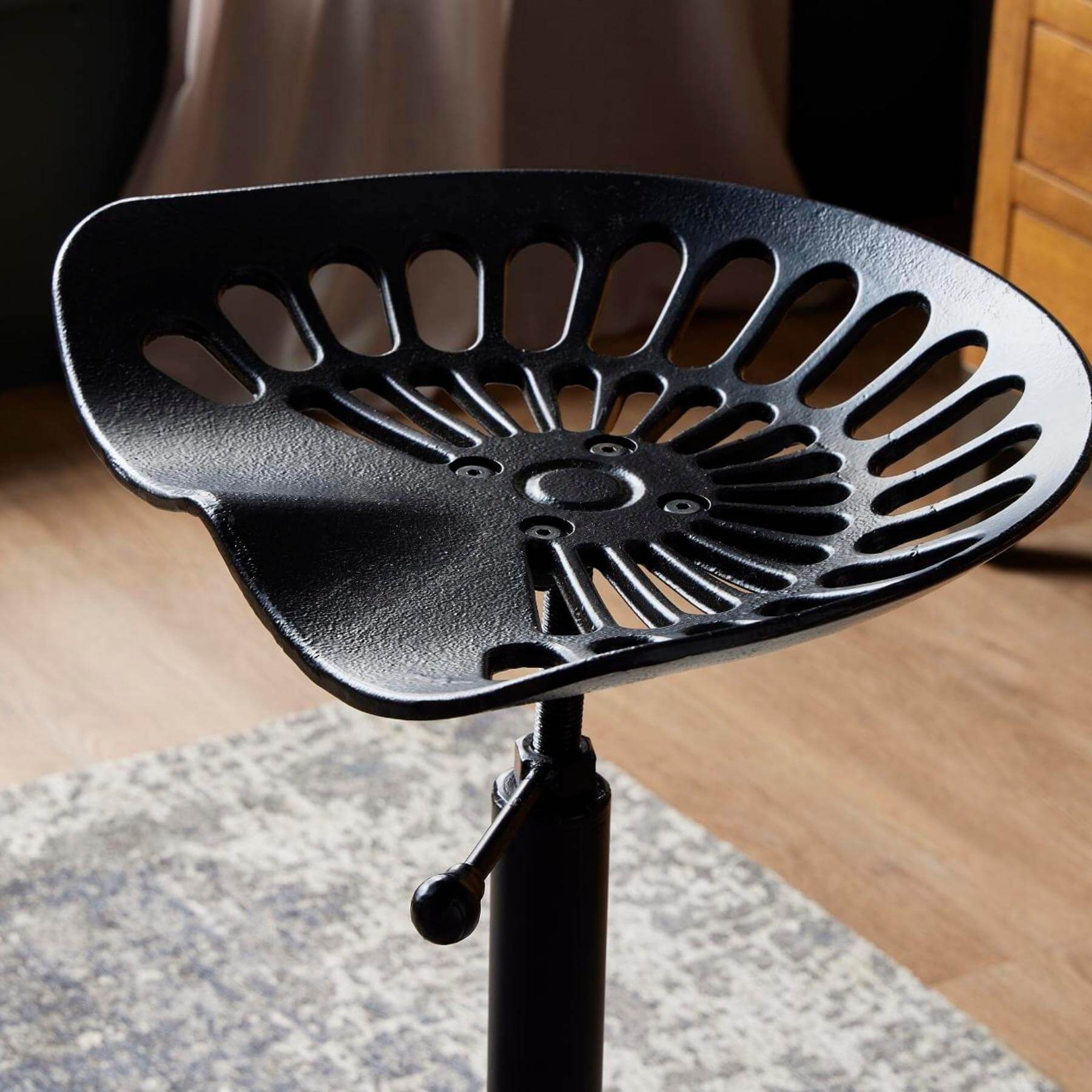 Black metal adjustable tractor stool with ergonomic seat for industrial-chic decor by RoomLondon at brixbailey.com