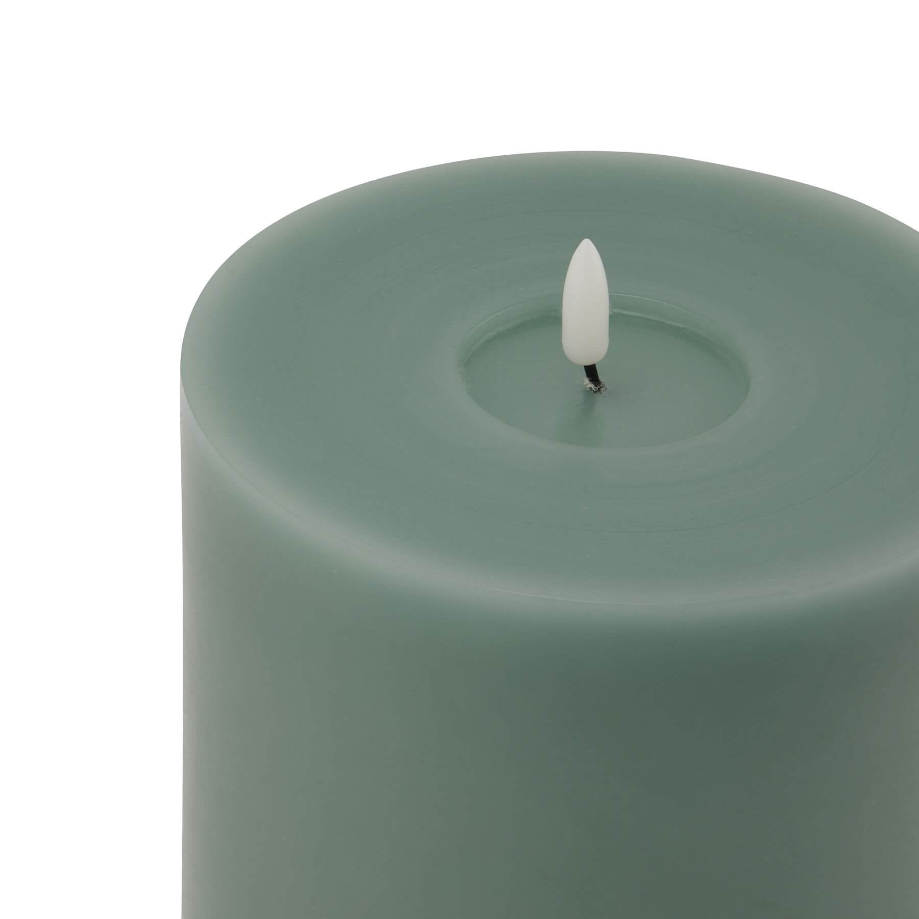 Sage green LED wax candle with realistic melt effect, warm glow, and modern decor styling by sostter at brixbailey.com