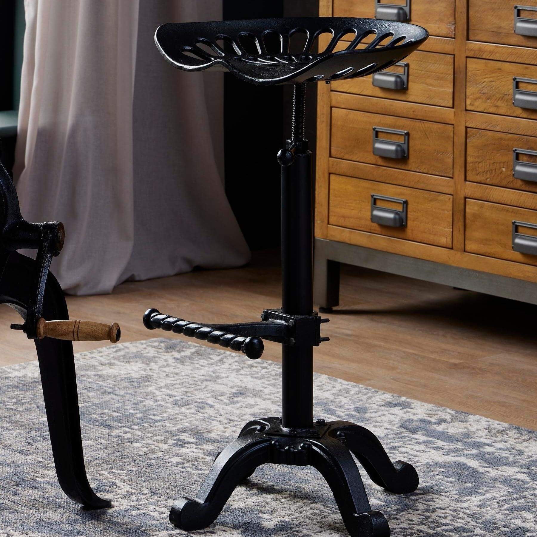 Adjustable black metal tractor seat stool with ergonomic design for industrial-chic decor by RoomLondon at brixbailey.com