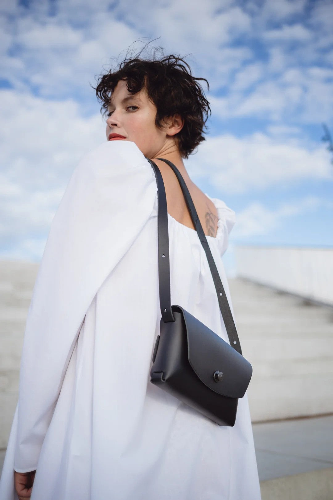 softly lit black leather clutch from mirgoods resting on a cozy surface