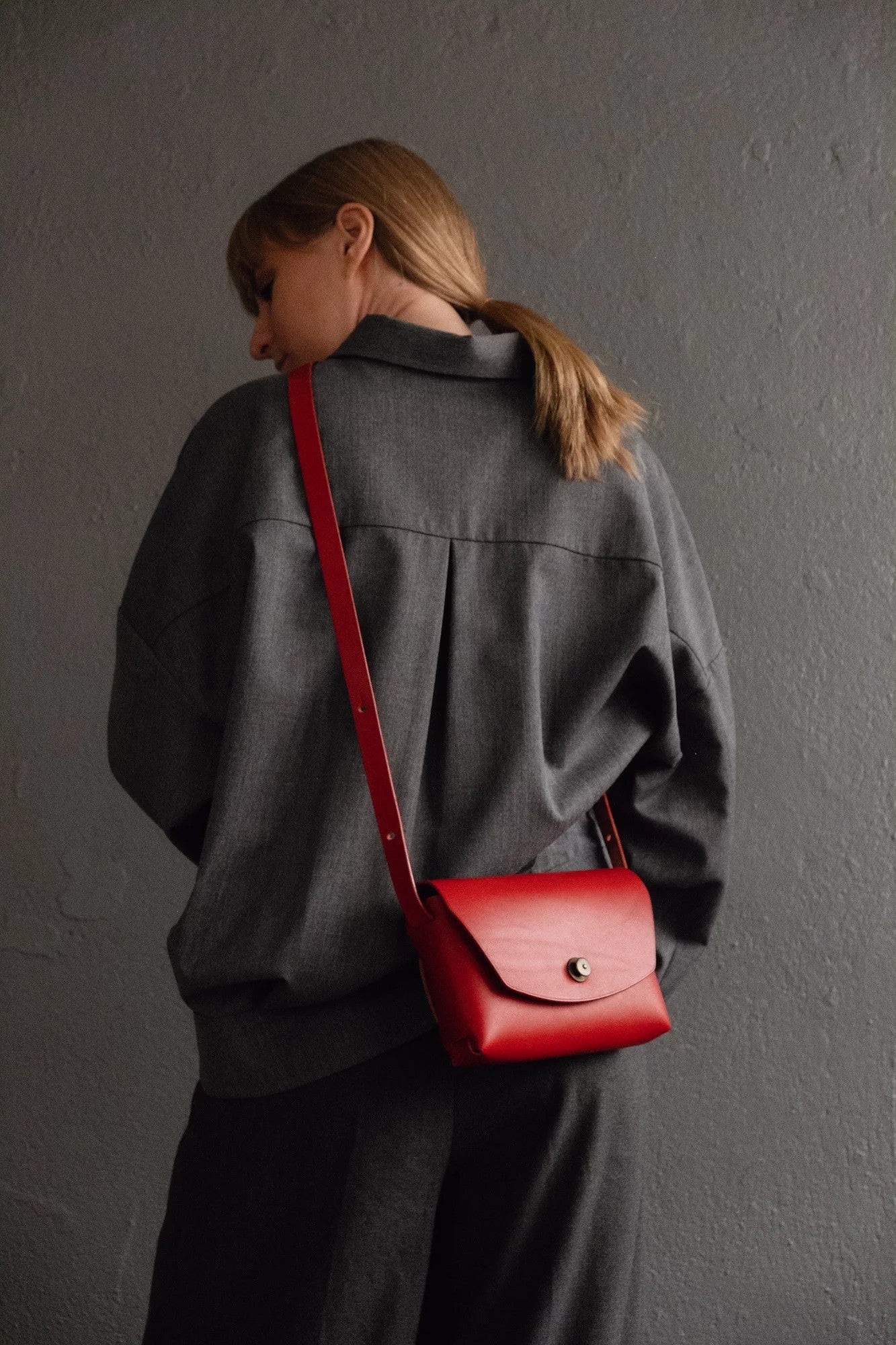 softly lit elegant red leather clutch bag resting on a cozy surface