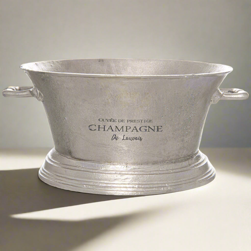 Antique silver champagne cooler with elegant detailing, handcrafted from premium metal, keeps drinks chilled in style. by Sostter at brixbailey.com