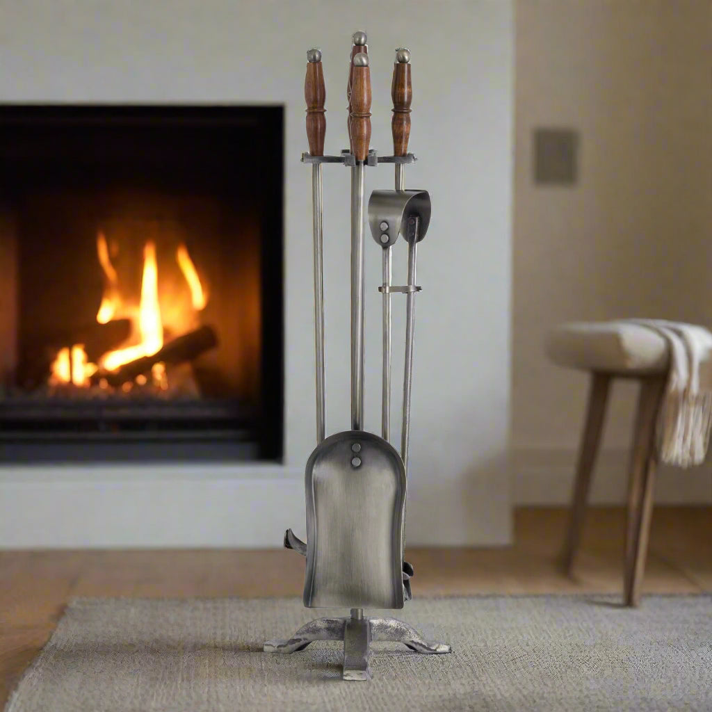 Handcrafted antique pewter fireplace set with wooden handles, earthy brown tones, and intricate metalwork. by Sostter at brixbailey.com