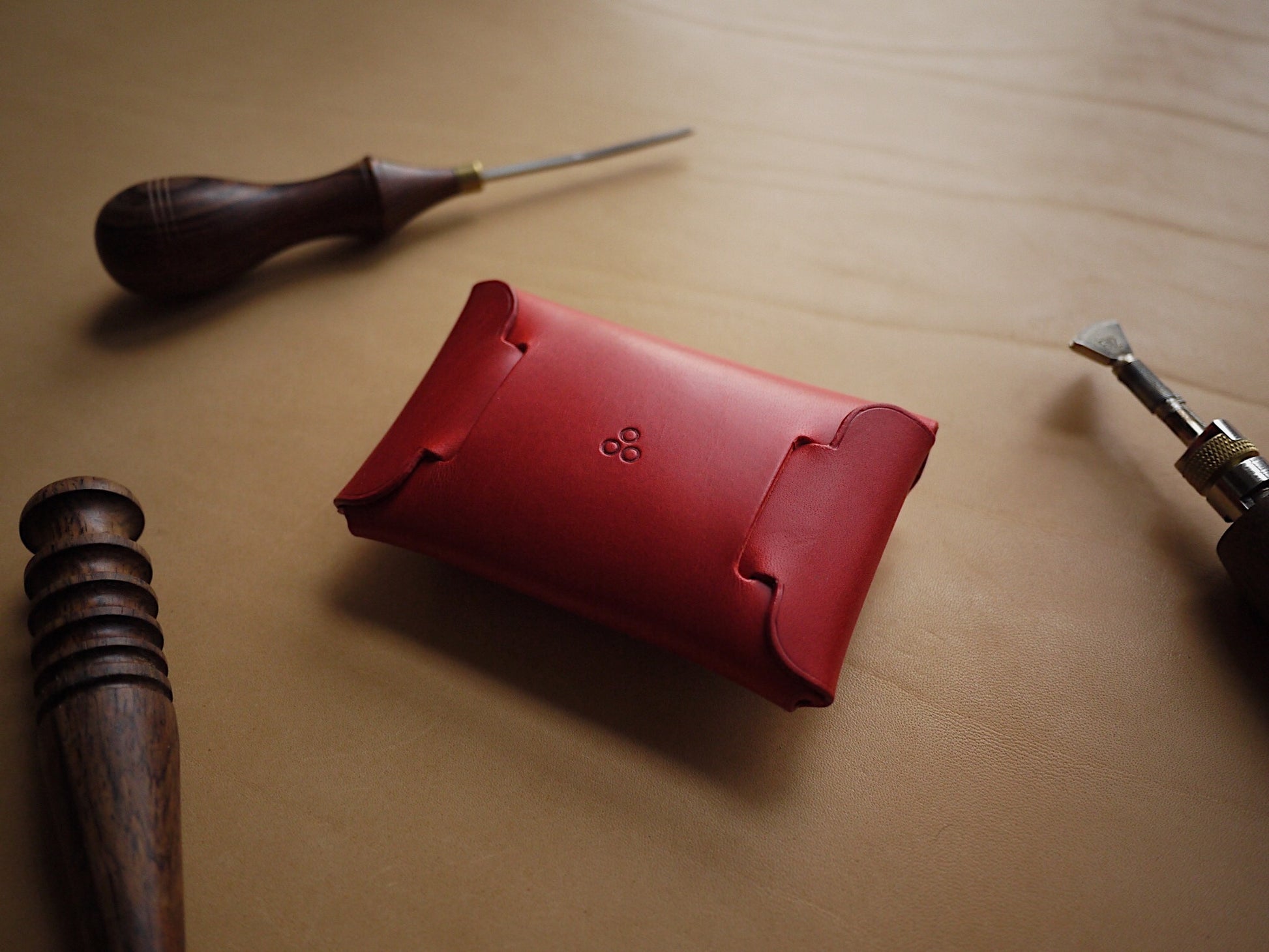 a soft, close-up view of the red handmade leather wallet showing its smooth texture and elegant creasing lines