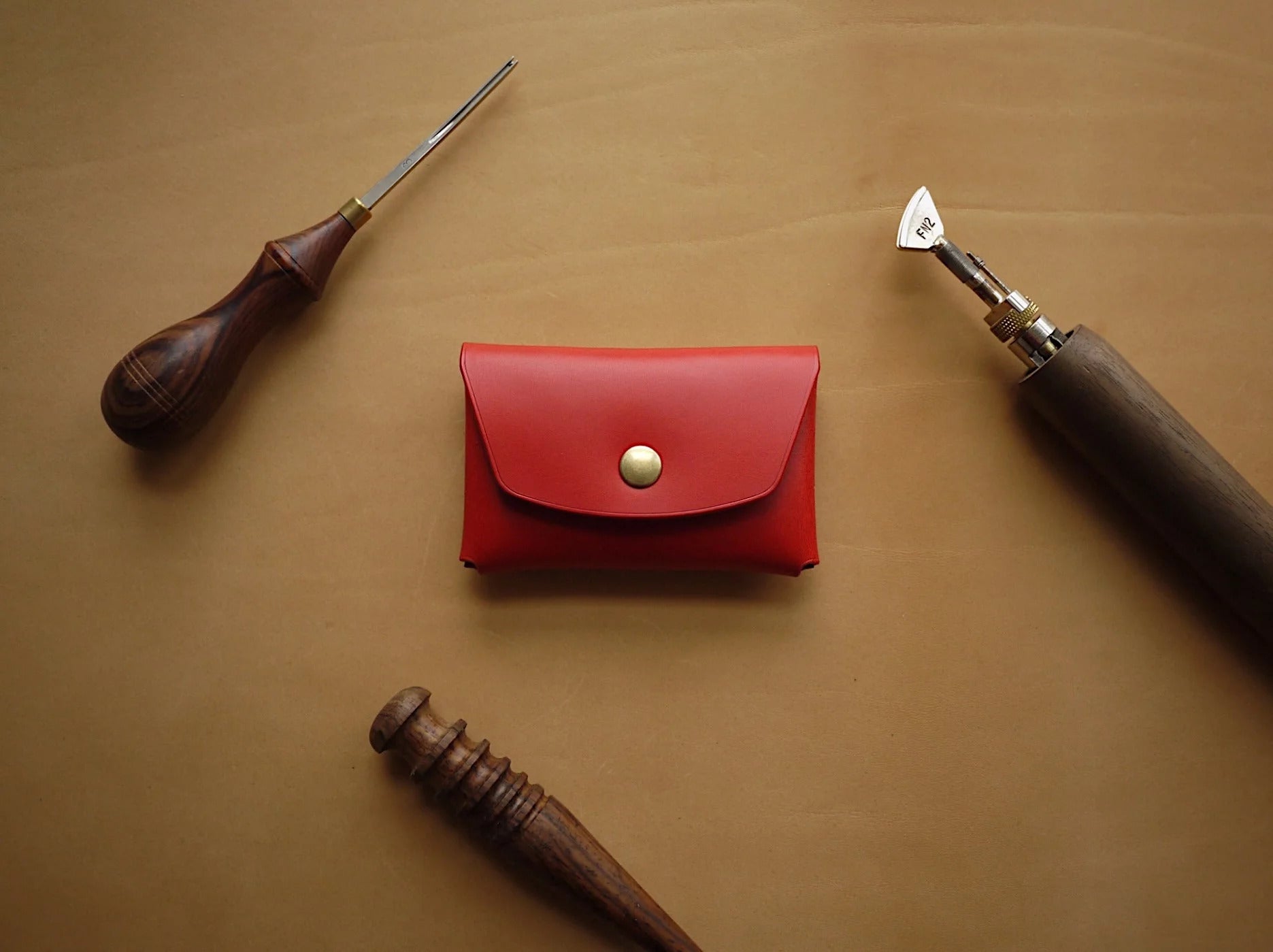 elegant red handmade leather wallet with polished edges and creasing lines, open to show card slots