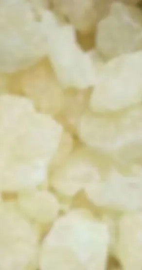 mellow pitch body oil in black glass bottle with dropper on a minimalist marble surface