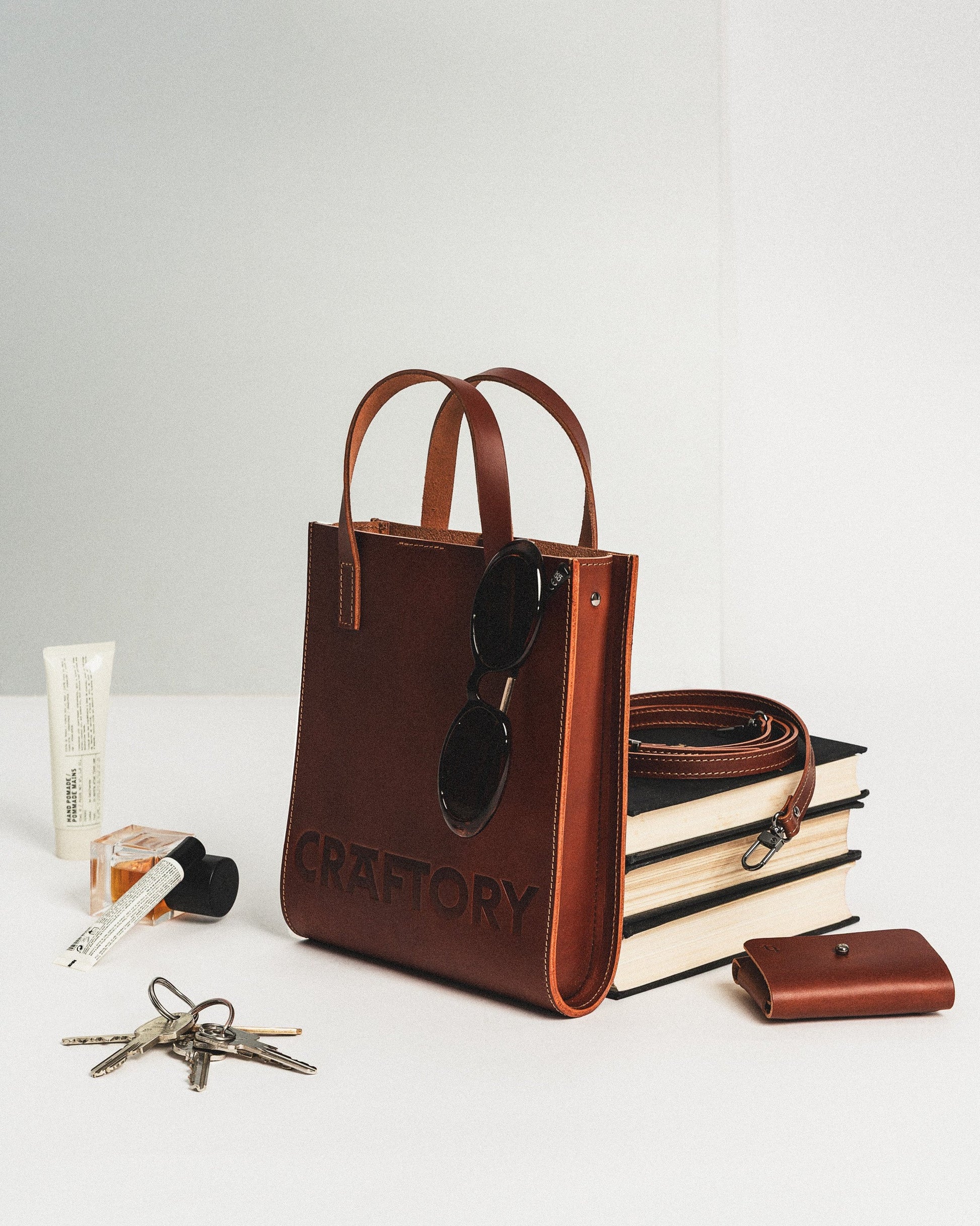 playful cognac bucket bag held by its handles against a bright, fun background