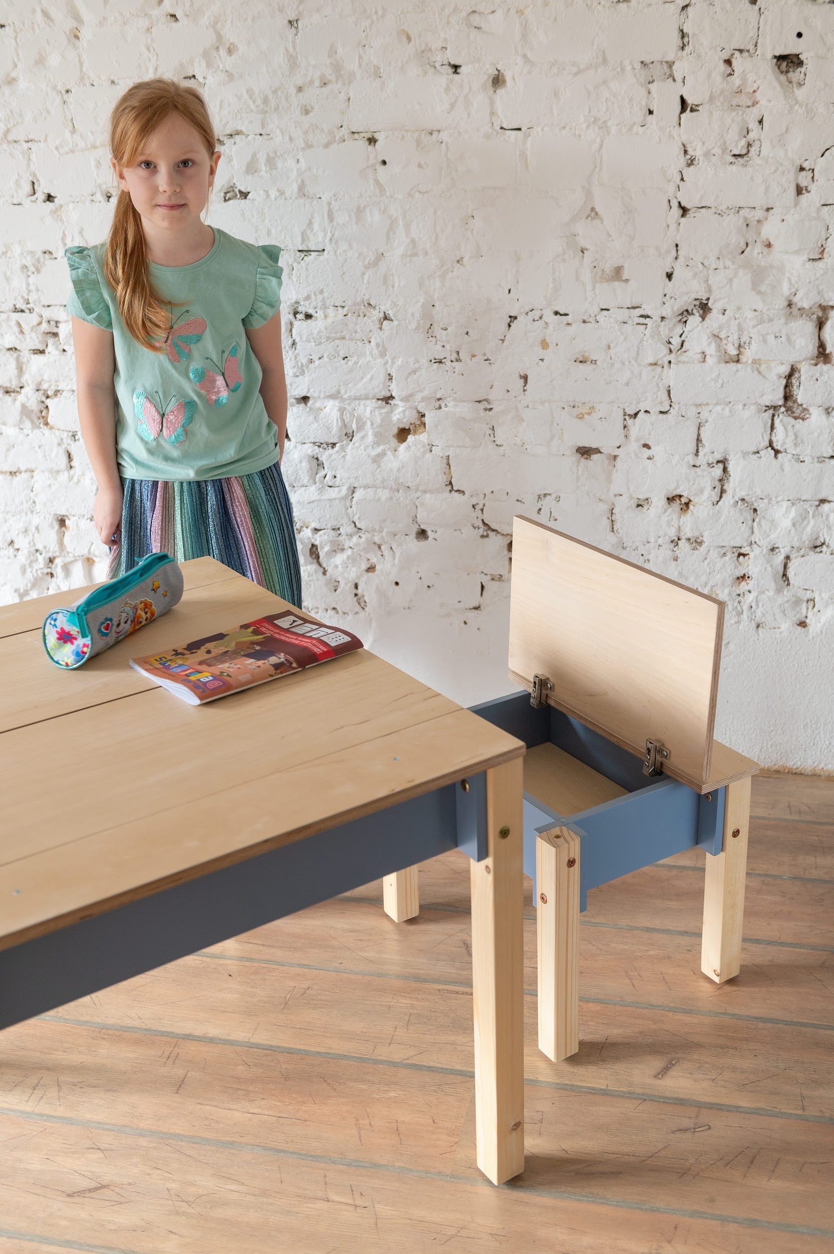 child organizing toys in the birch plywood chair's hidden storage compartment