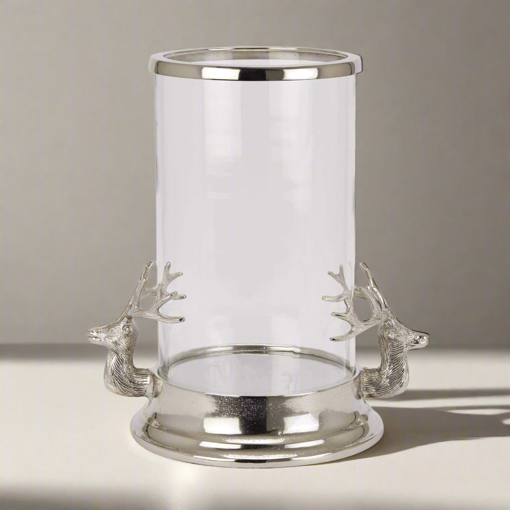 Silver Stag Heads Hurricane Lantern with glass cylinder, polished metal finish, and intricate stag accents for home decor by sostter at brixbailey.com