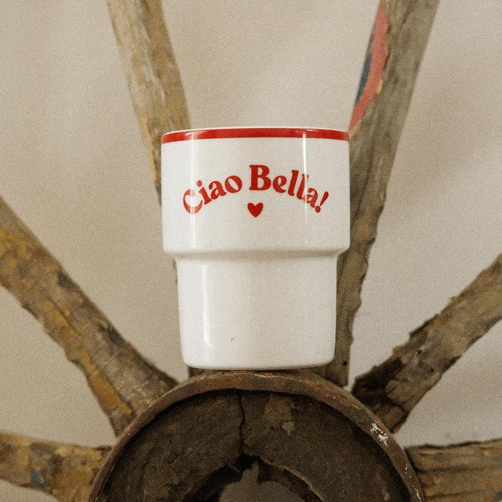 playful ciao bella mug held by a smiling person on a sunny balcony