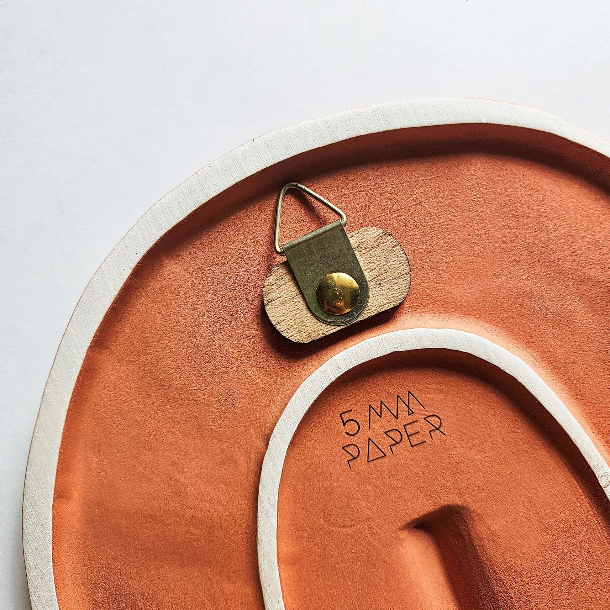 handcrafted portuguese ceramic wall mask with a textured matte terracotta finish in a modern home setting