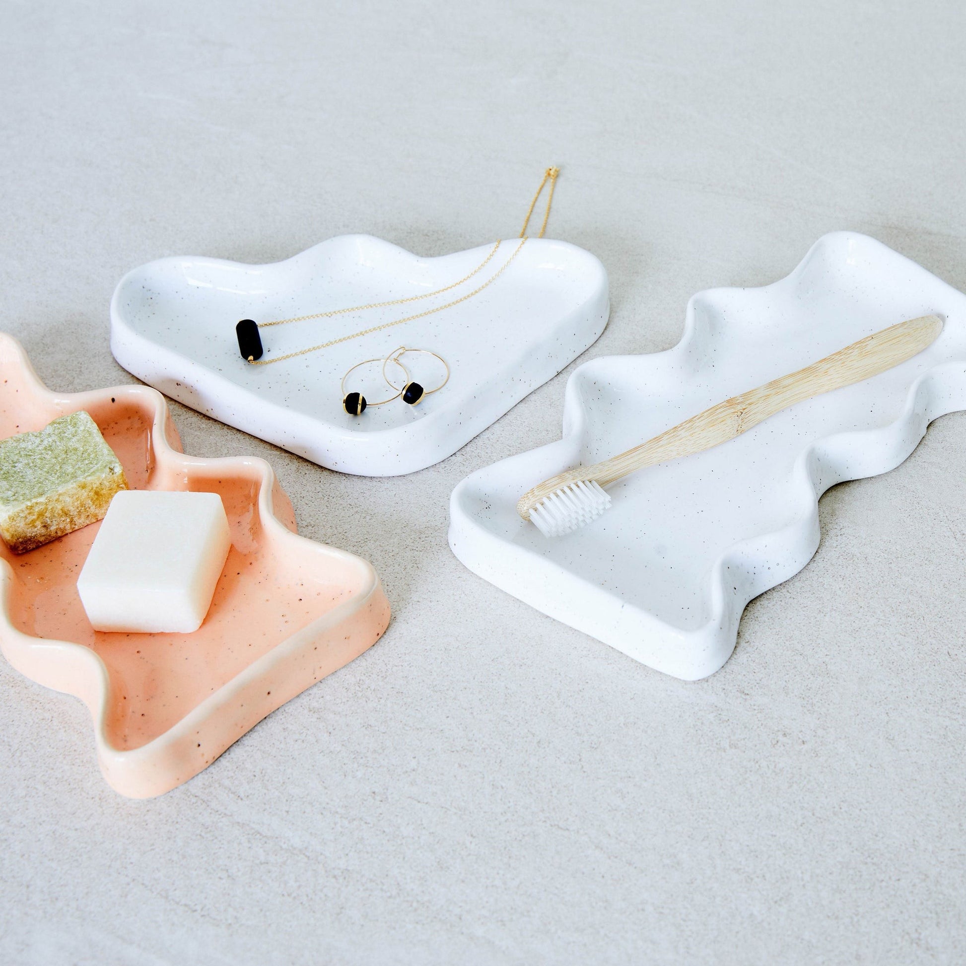 bold triangular ceramic wave tray with a dynamic speckled white glaze on a dark surface