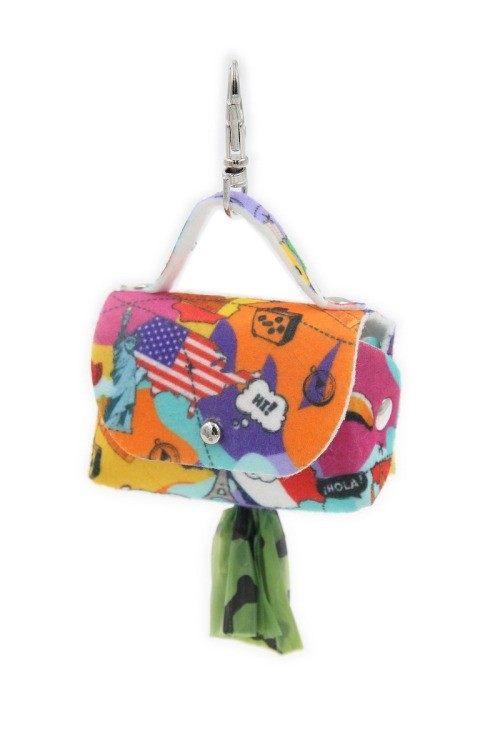 playful felt dog bag dispenser clipped to a backpack on a sunny walk