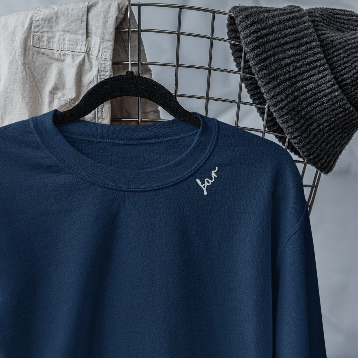 a soft beige organic cotton sweatshirt with a dark brown embroidered far detail