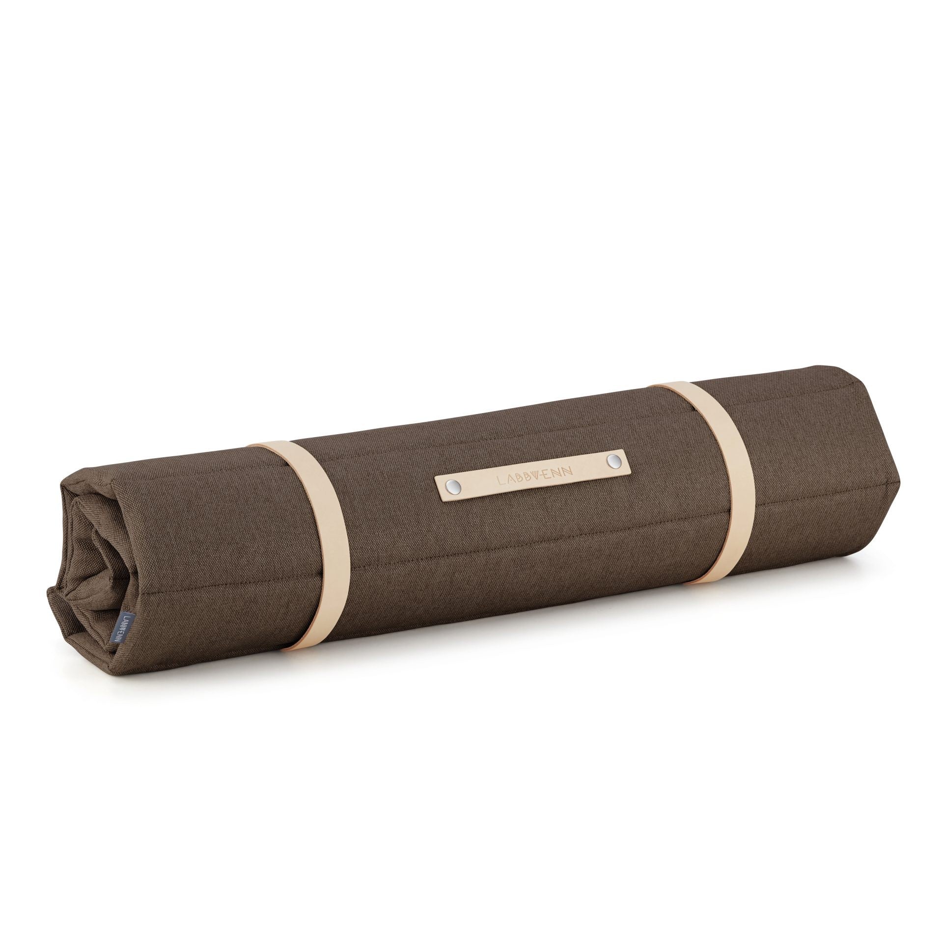 a confident dog resting on a brown quilted travel mat with a full-grain leather belt