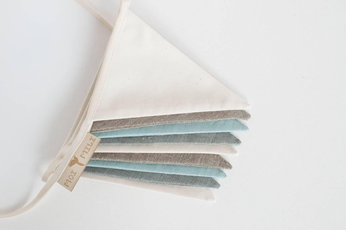 close-up of a whimsical linen garland with teal and grey pennants, perfect for a child's eco-friendly room