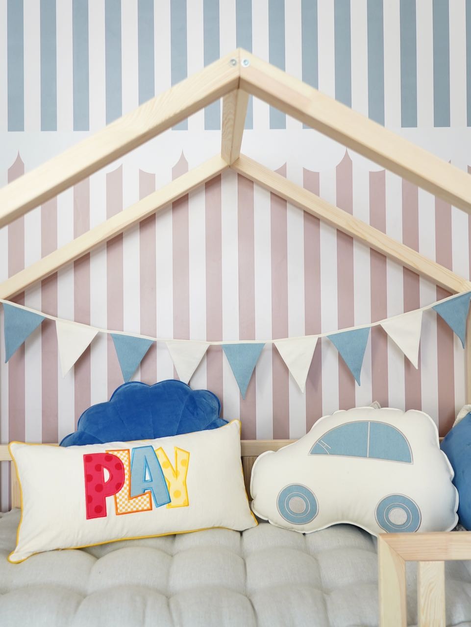 soft cotton and linen jeans garland draped over a rustic wooden crib, creating a cozy nursery vibe