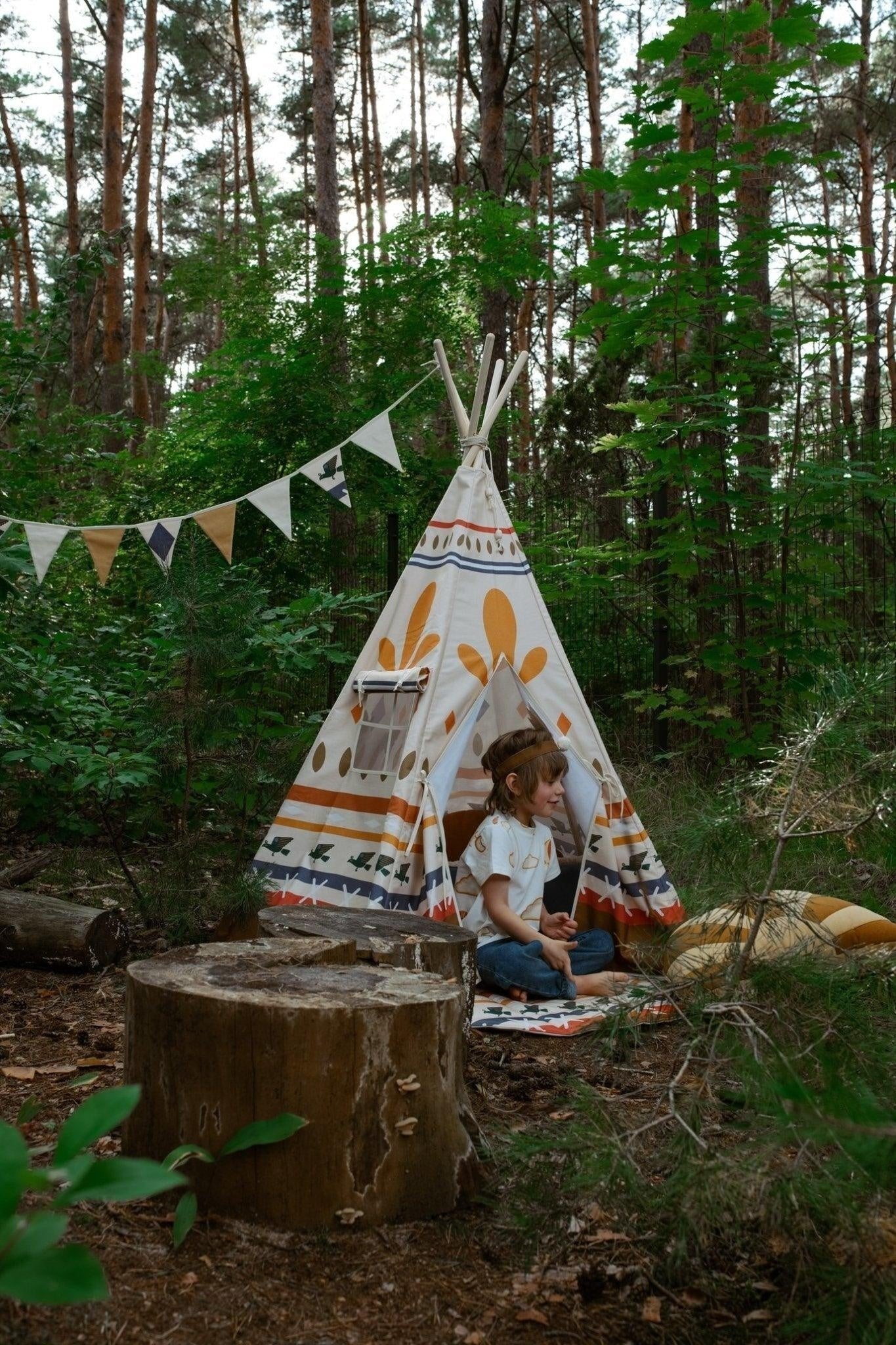 playful native vibe cotton garland with warm geometric shapes draped over a toy teepee