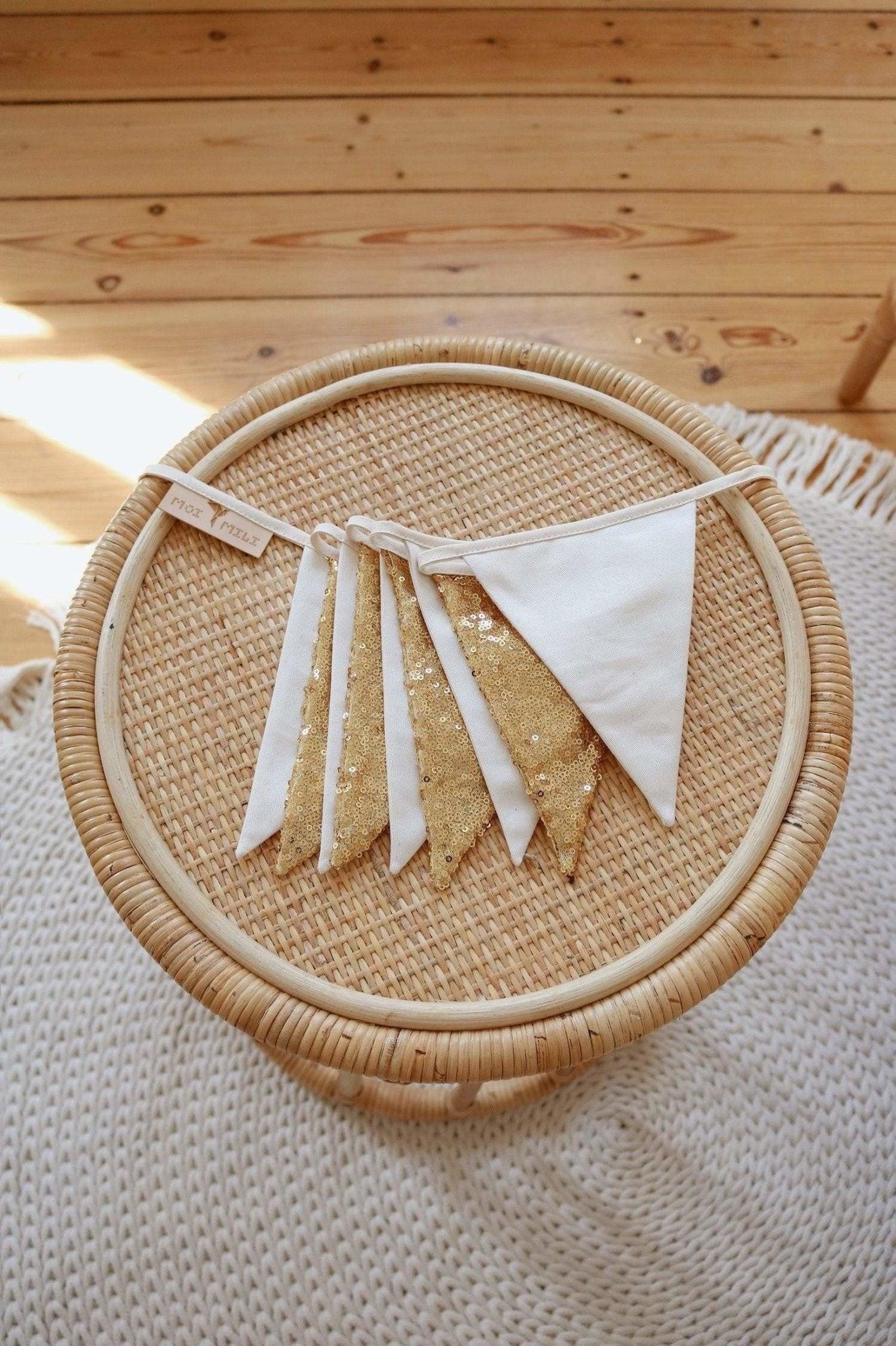 soft gold and beige sequin garland draped gently over a wooden crib, creating a cozy nursery ambiance