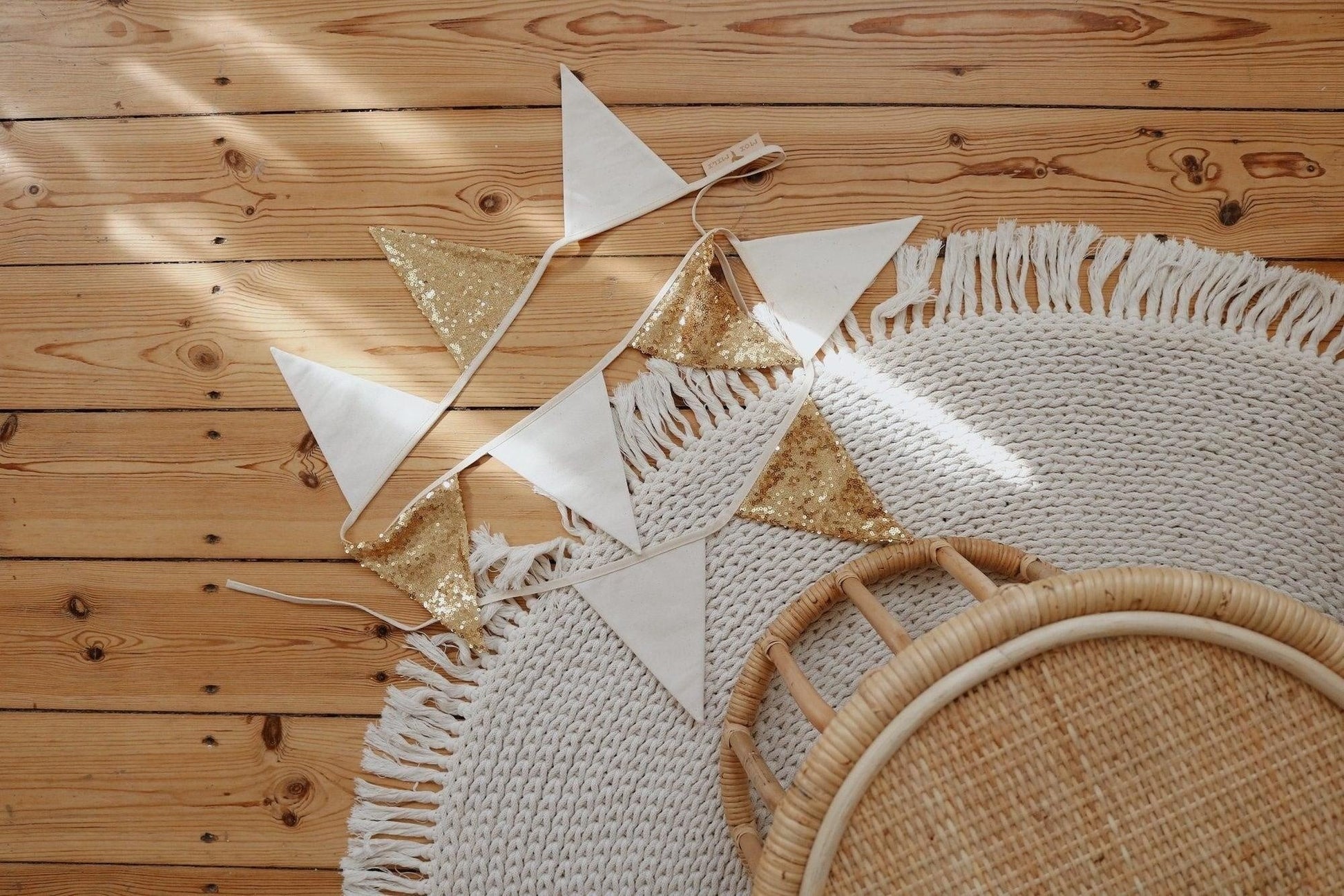 gold and beige sequin garland draped over a wooden crib, adding a functional yet stylish touch to a nursery
