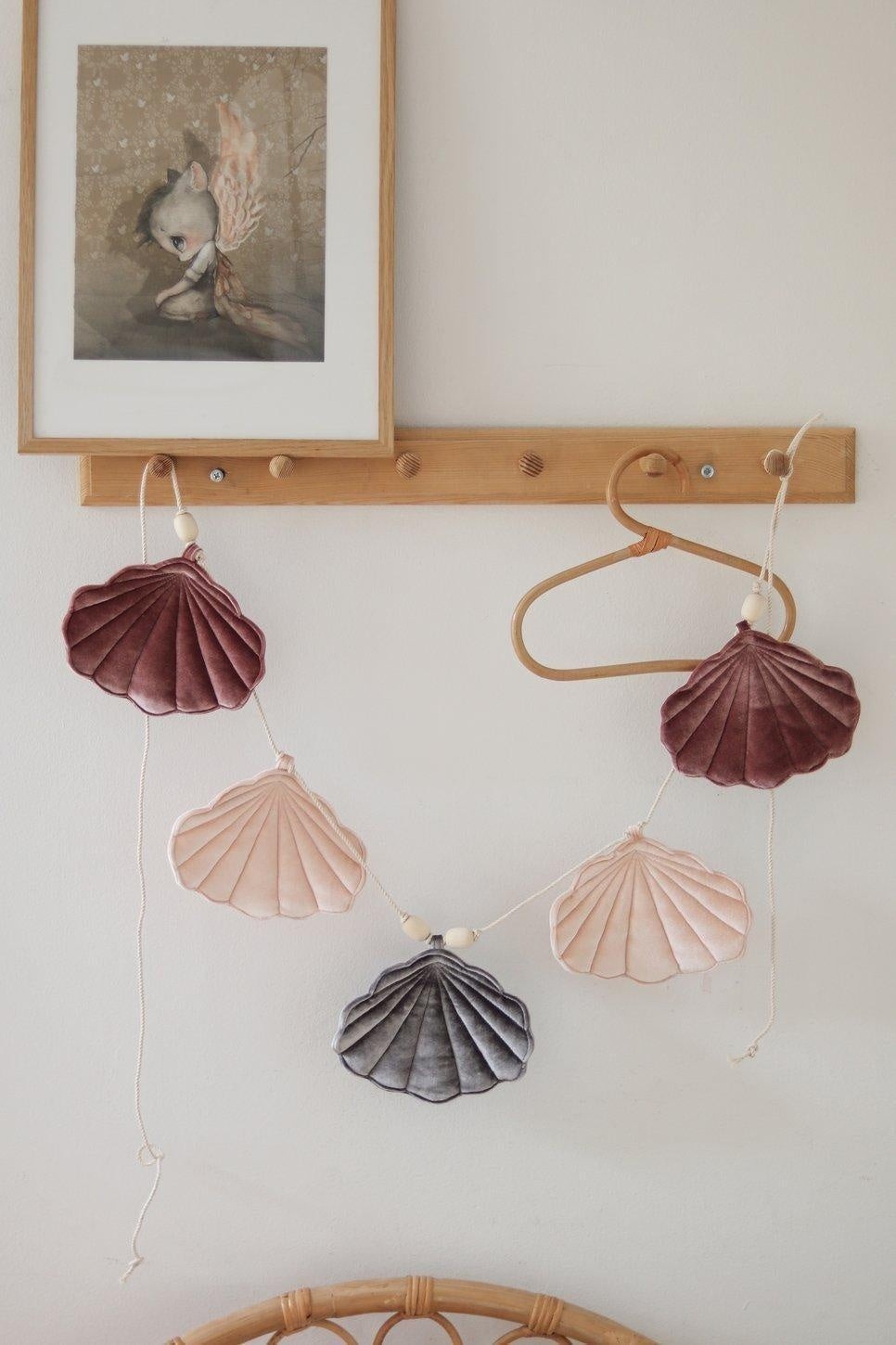 soft pastel shell garland with velvet marsala and apricot shells, hanging gently on a cotton string with wooden beads
