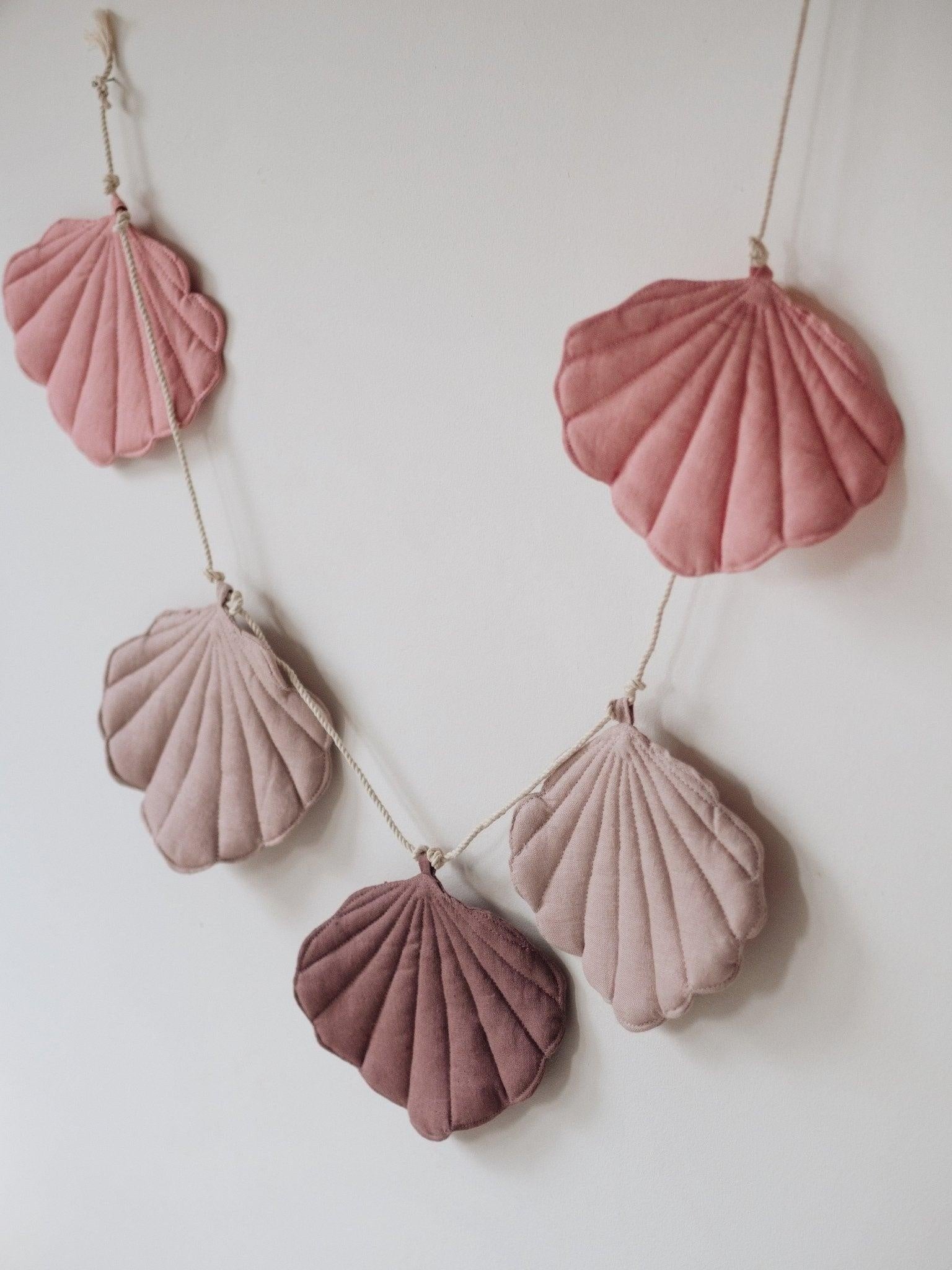 elegant powder pink and marsala linen shell garland with wooden beads, draped over a canopy