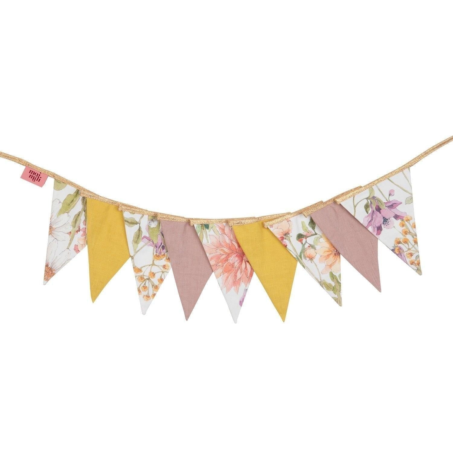 soft cotton and linen wildflower garland draped gently over a sunlit nursery crib