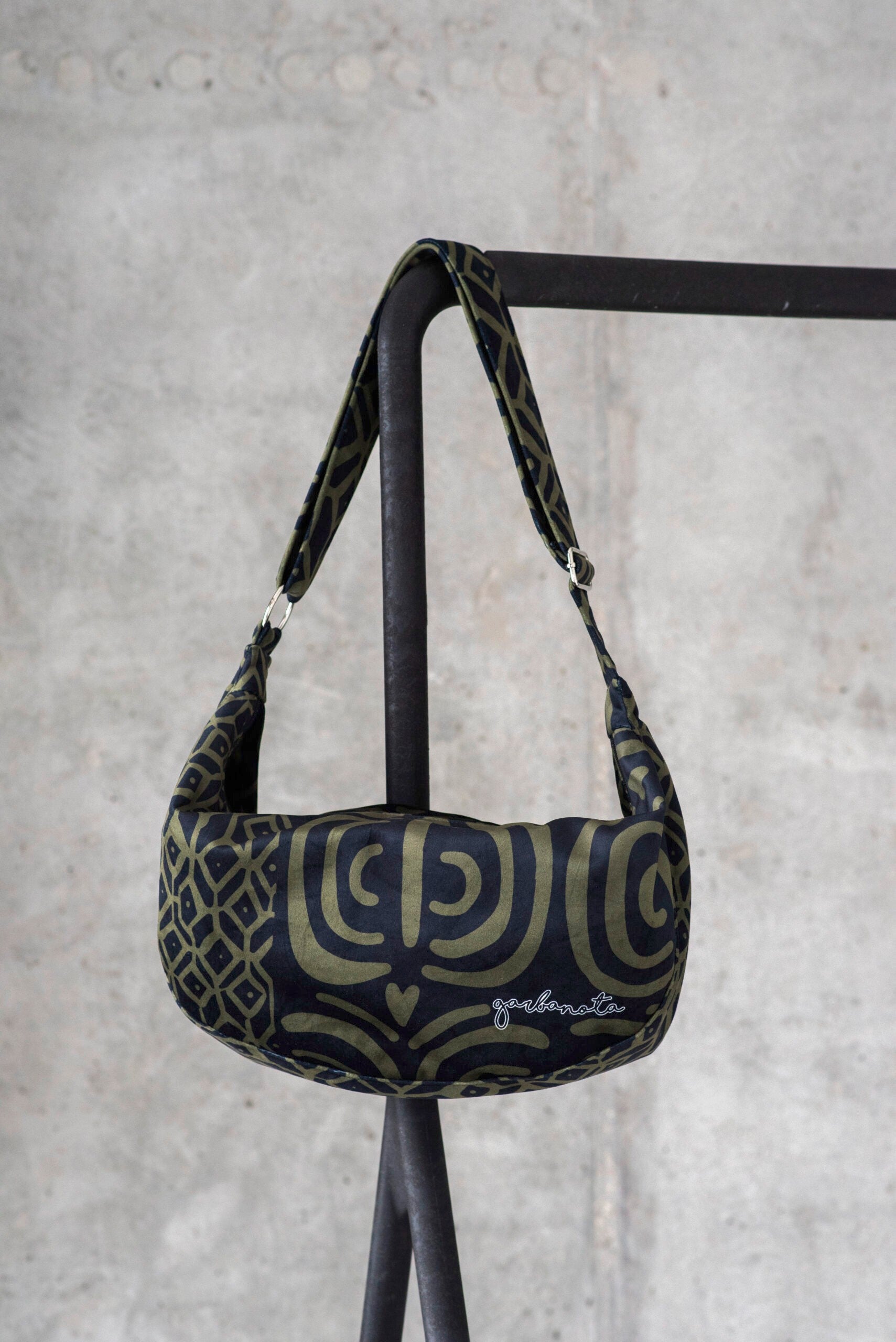 playful woman swinging a stylish khaki velour hobo bag on a sunny day