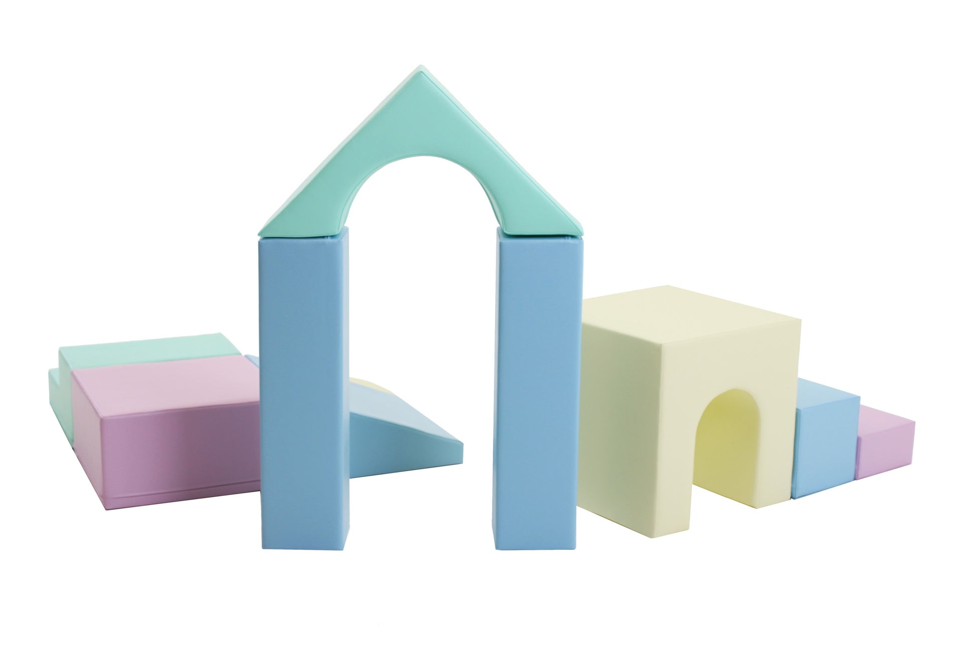 a child's hand stacking pastel iglu foam blocks on a soft play mat