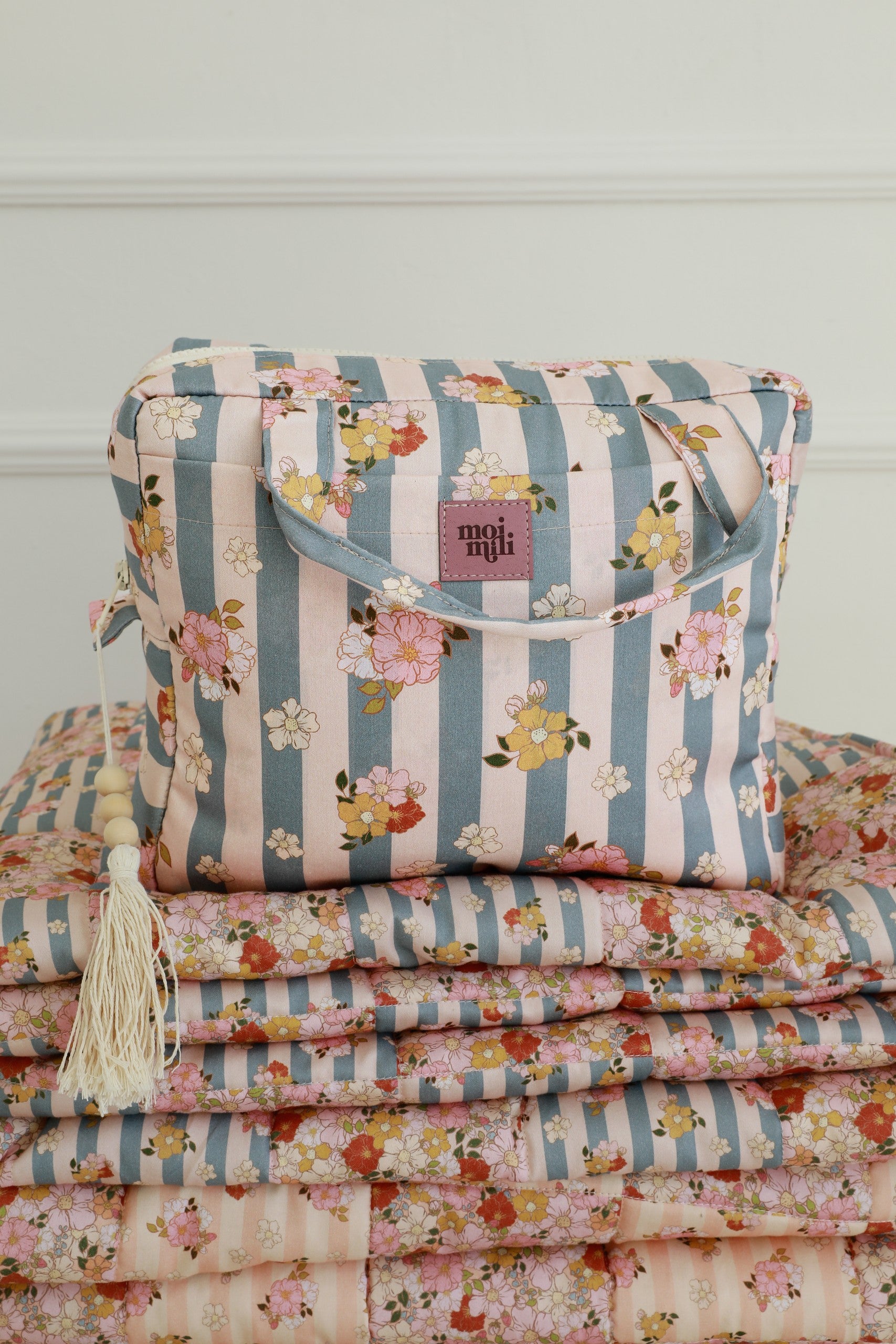 bold blue striped makeup bag with waterproof lining, open to show spacious interior and pockets