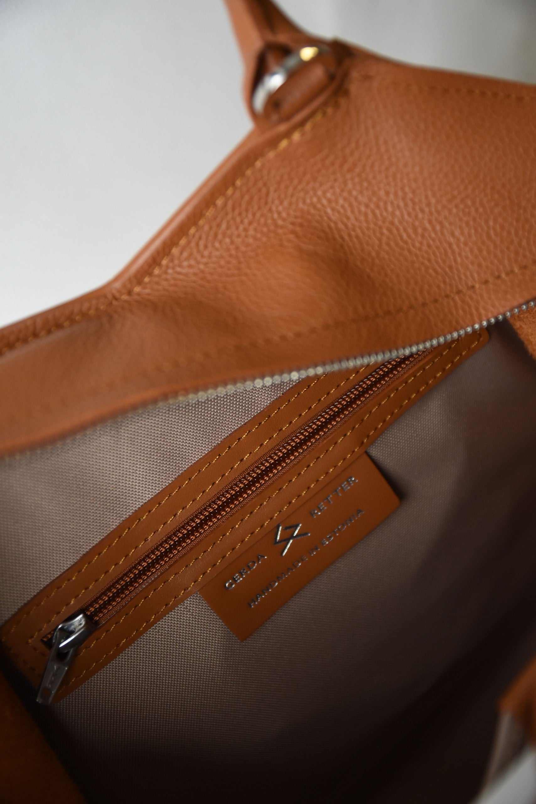 elegant handmade leather tote bag by gerda retter, showcasing its refined silhouette and sophisticated texture in soft light