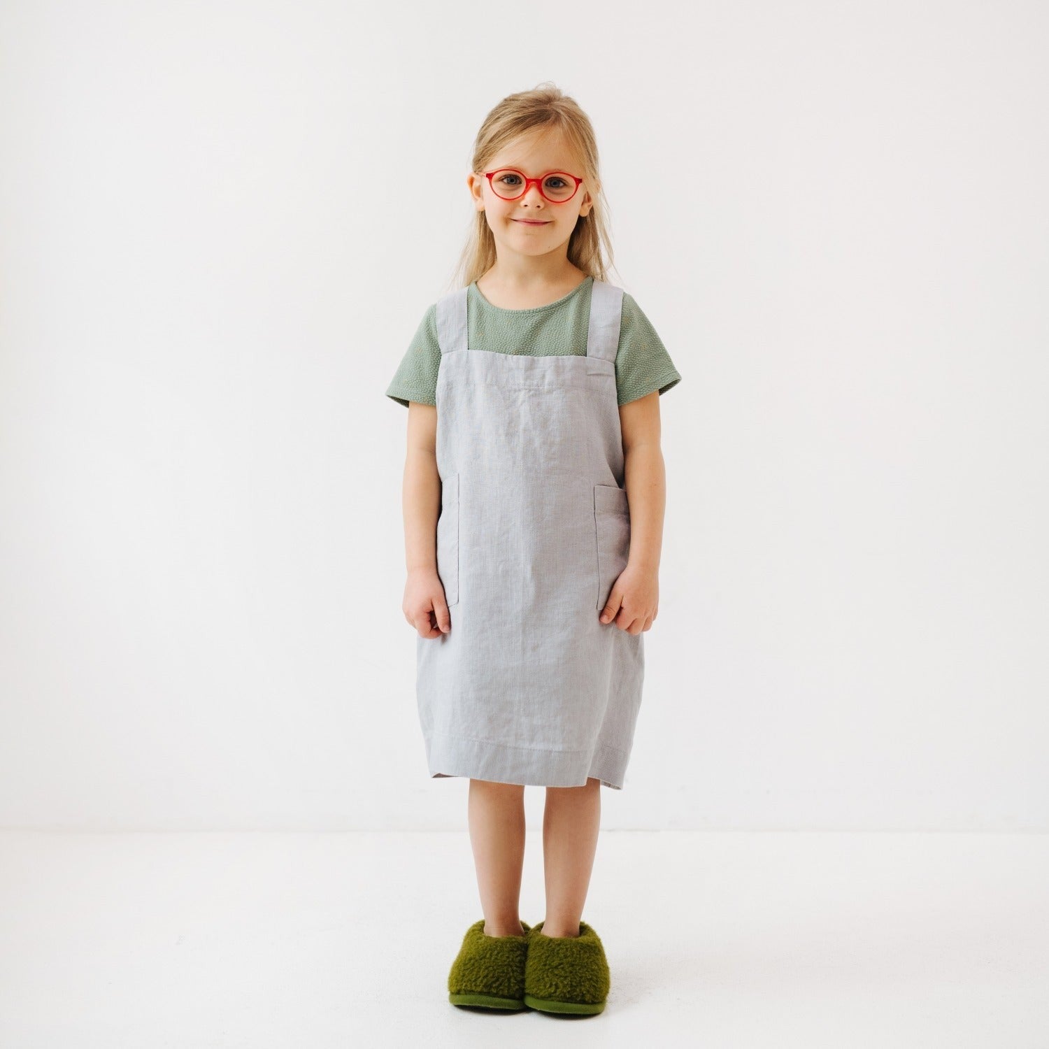 elegant light grey linen pinafore apron for kids, shown in a refined kitchen setting with soft natural light