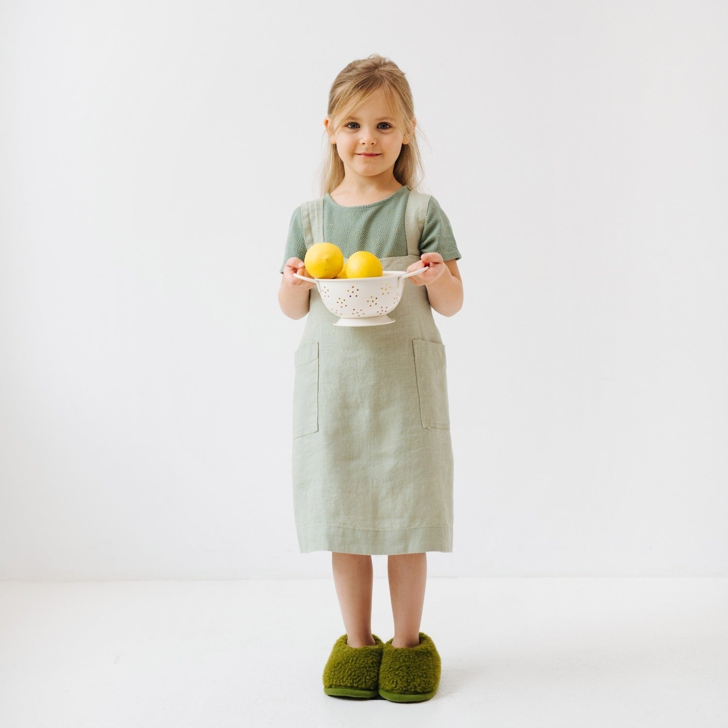 elegant sage linen kids apron with deep pockets, shown in soft natural light