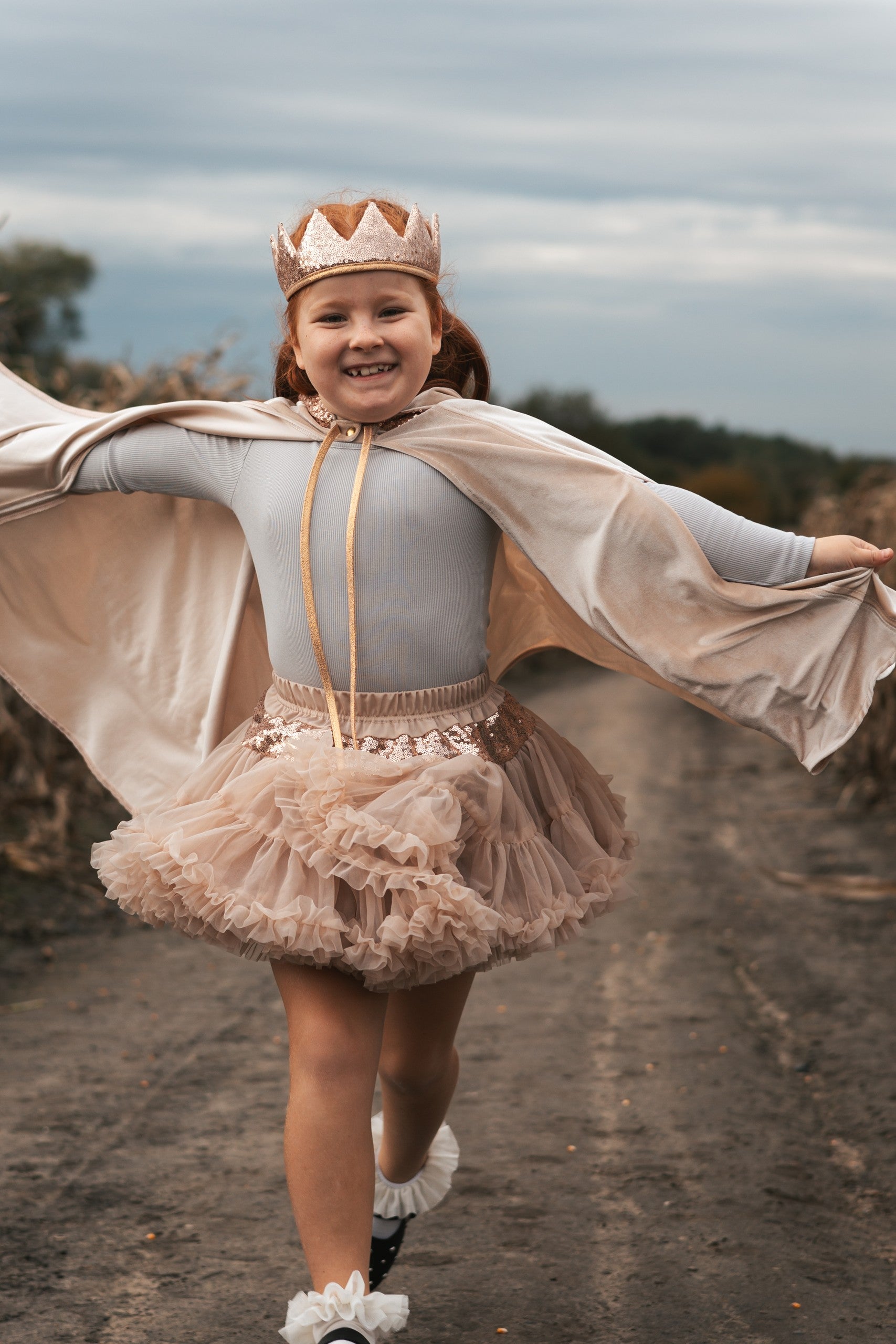 bold front view of a cream pearl magic cape with a deep hood and snap fastening