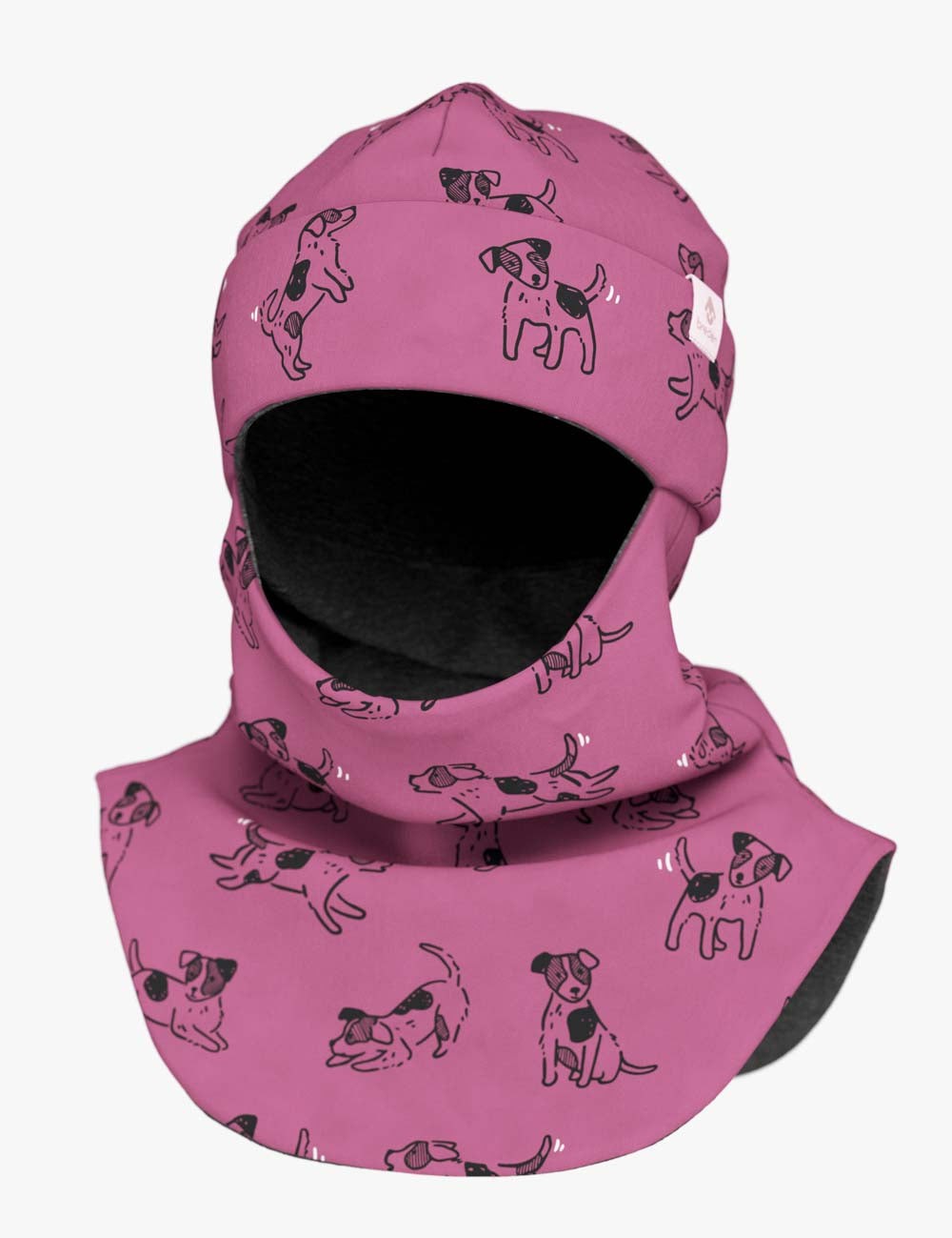 a child peeking out playfully from a pink dog-print merino balaclava in soft morning light