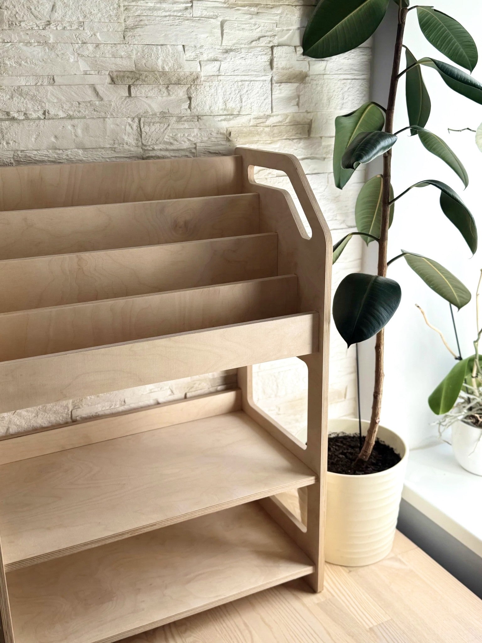 montessori bookshelf in a sunlit nursery with soft toys and books neatly arranged