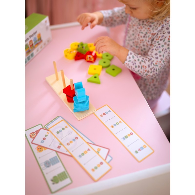 a close-up shot of a child's hands stacking the wooden animal puzzle pyramid on a natural wood table