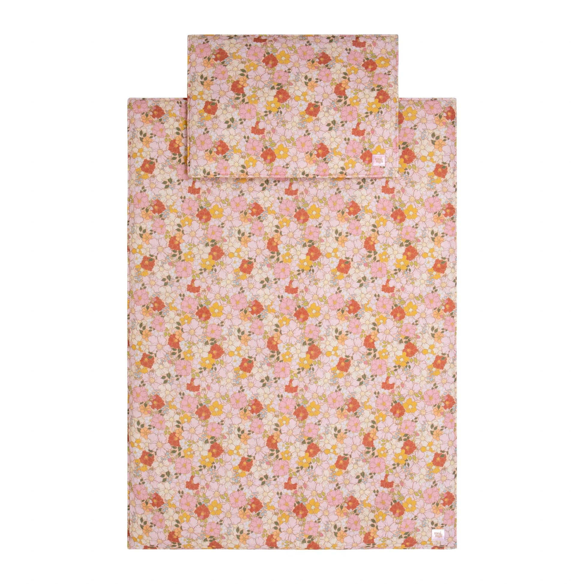bold close-up of a handmade muslin baby blanket and pillow set with a vibrant spring garden print