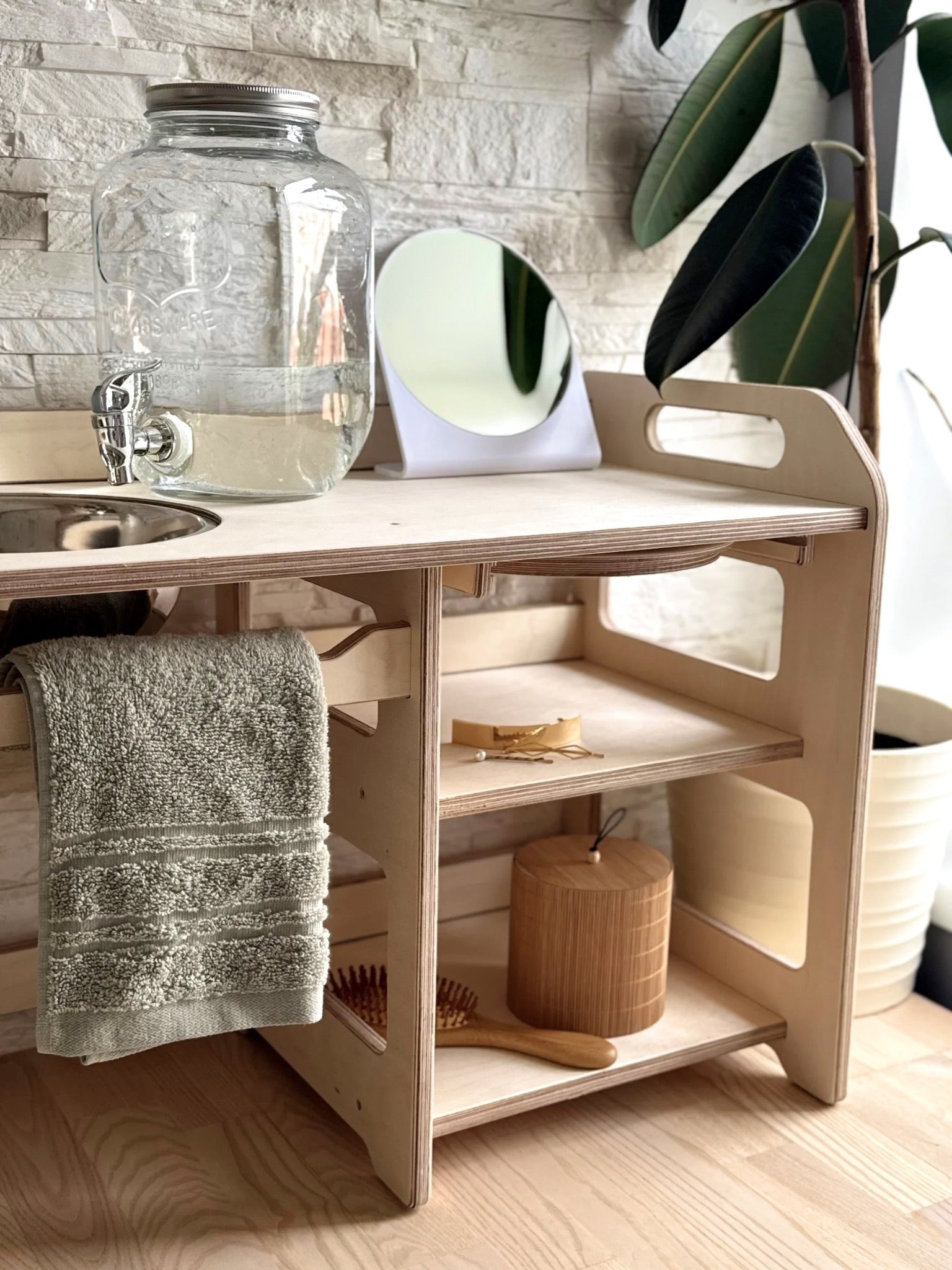 a montessori wooden washbasin for toddlers in a bright, airy room with morning light