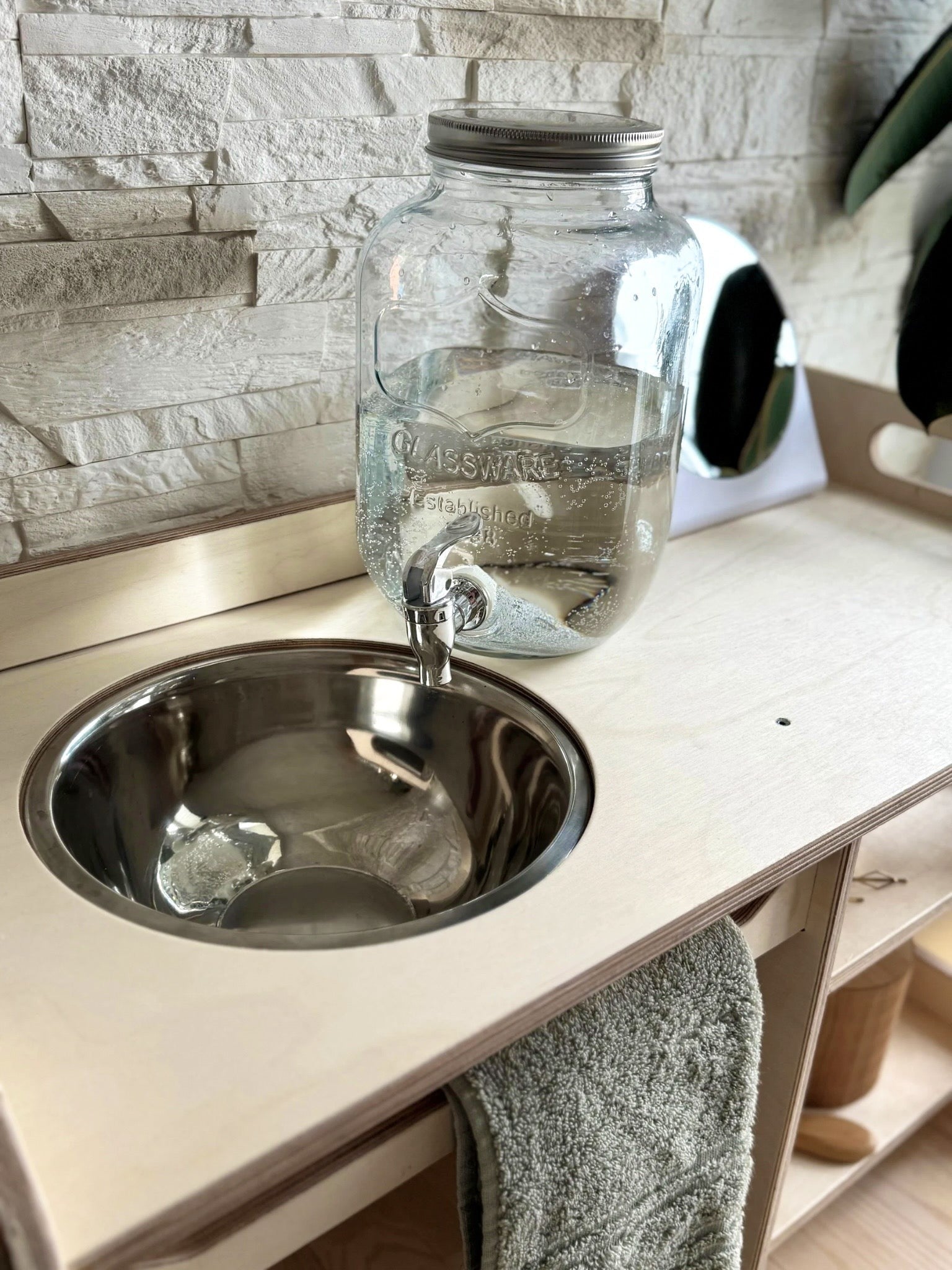 a bold, low-angle shot of the montessori wooden washbasin highlighting its sturdy, toddler-ready design
