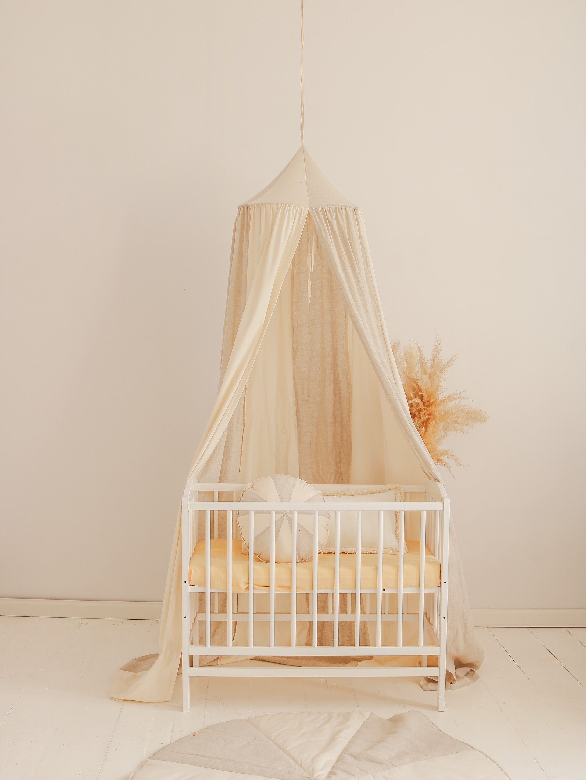 cream and grey organic cotton linen canopy hanging over a cozy reading nook with soft natural light