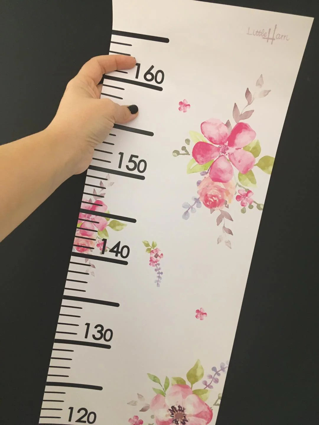a playful princess growth chart on a nursery wall with a teddy bear propped beside it