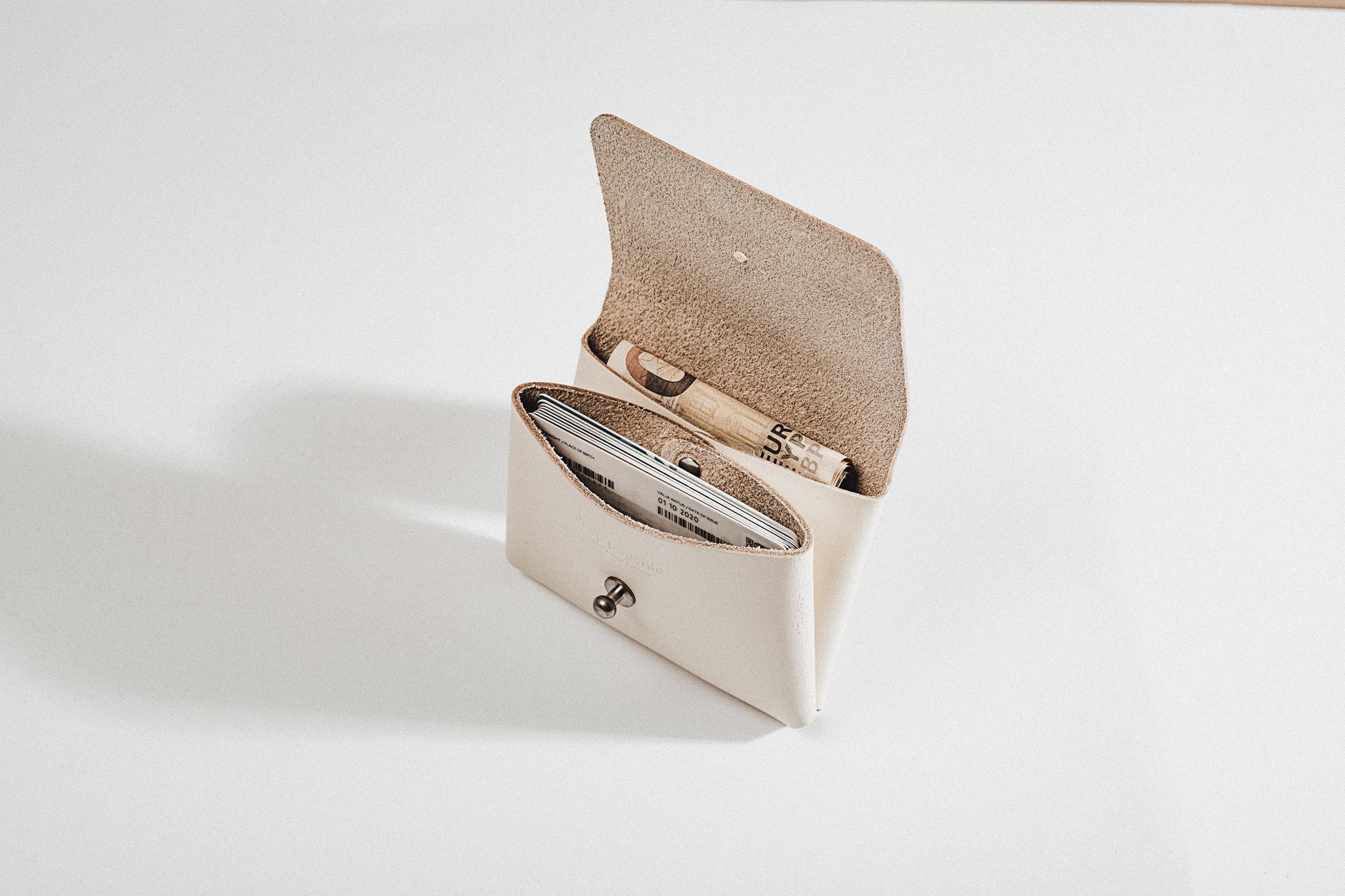 a minimalist deep pouchie wallet held open to show its spacious dual compartments and functional interior