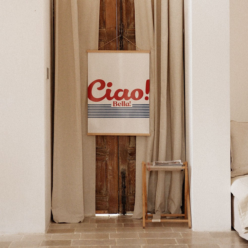 playful ciao bella poster on a vibrant yellow wall in a sunlit kitchen