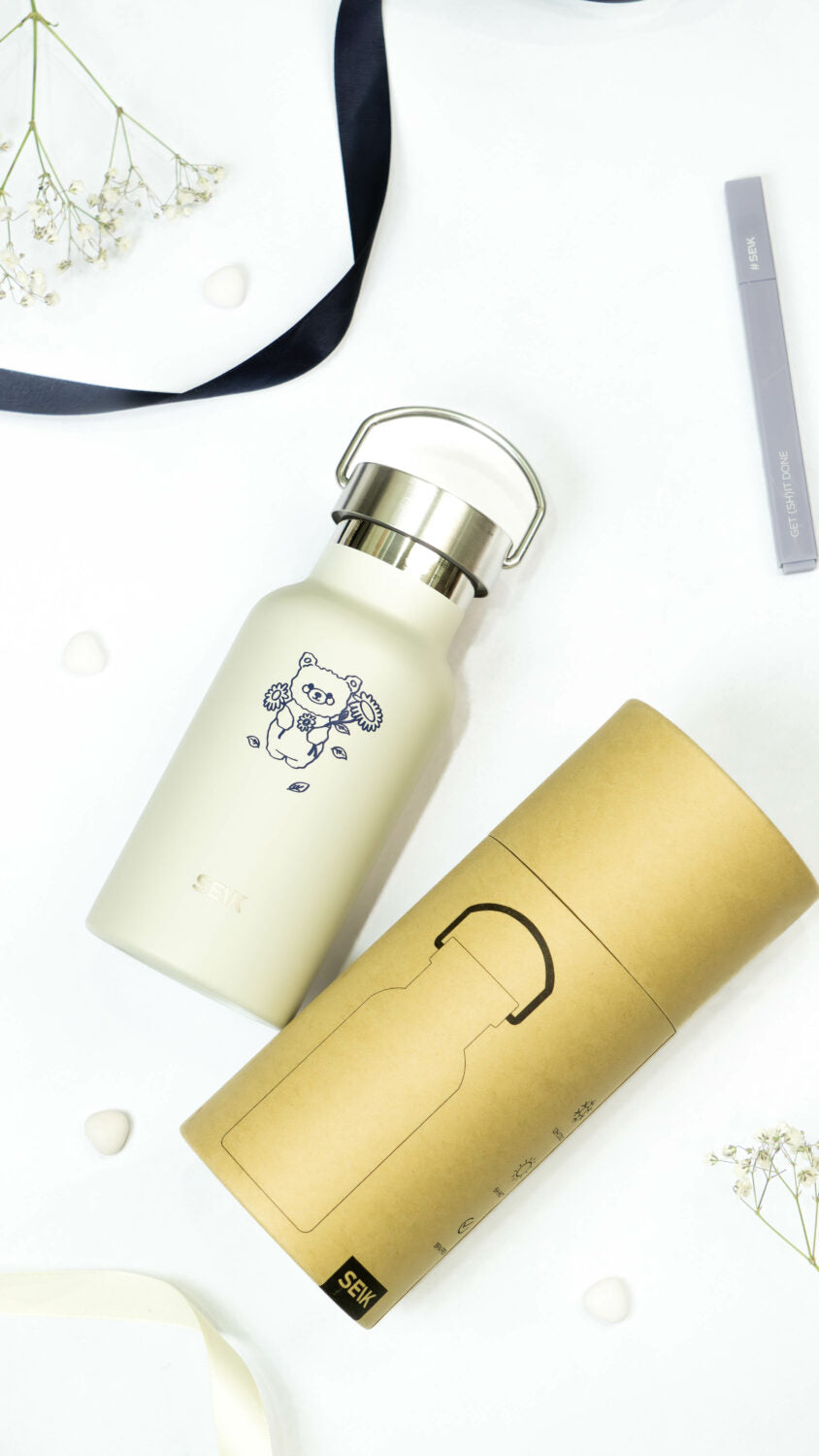 a soft beige bear water bottle held in gentle hands, evoking a cozy and comforting feeling