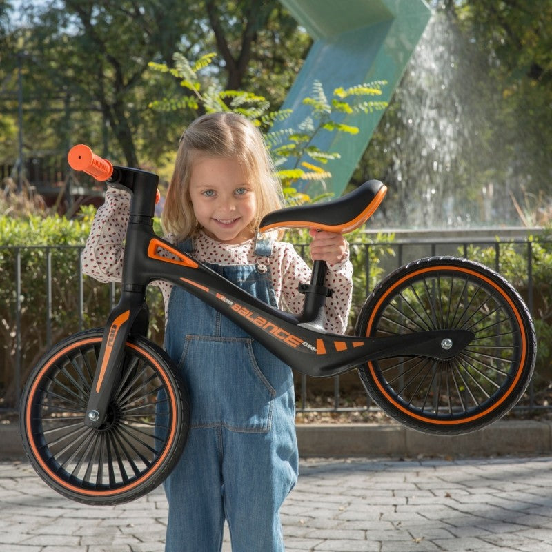 a toddler's small hands gripping the soft rubber handlebars of a lightweight balance bike