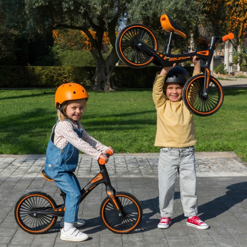 bold toddler confidently riding a lightweight sporty balance bike on a sunny day