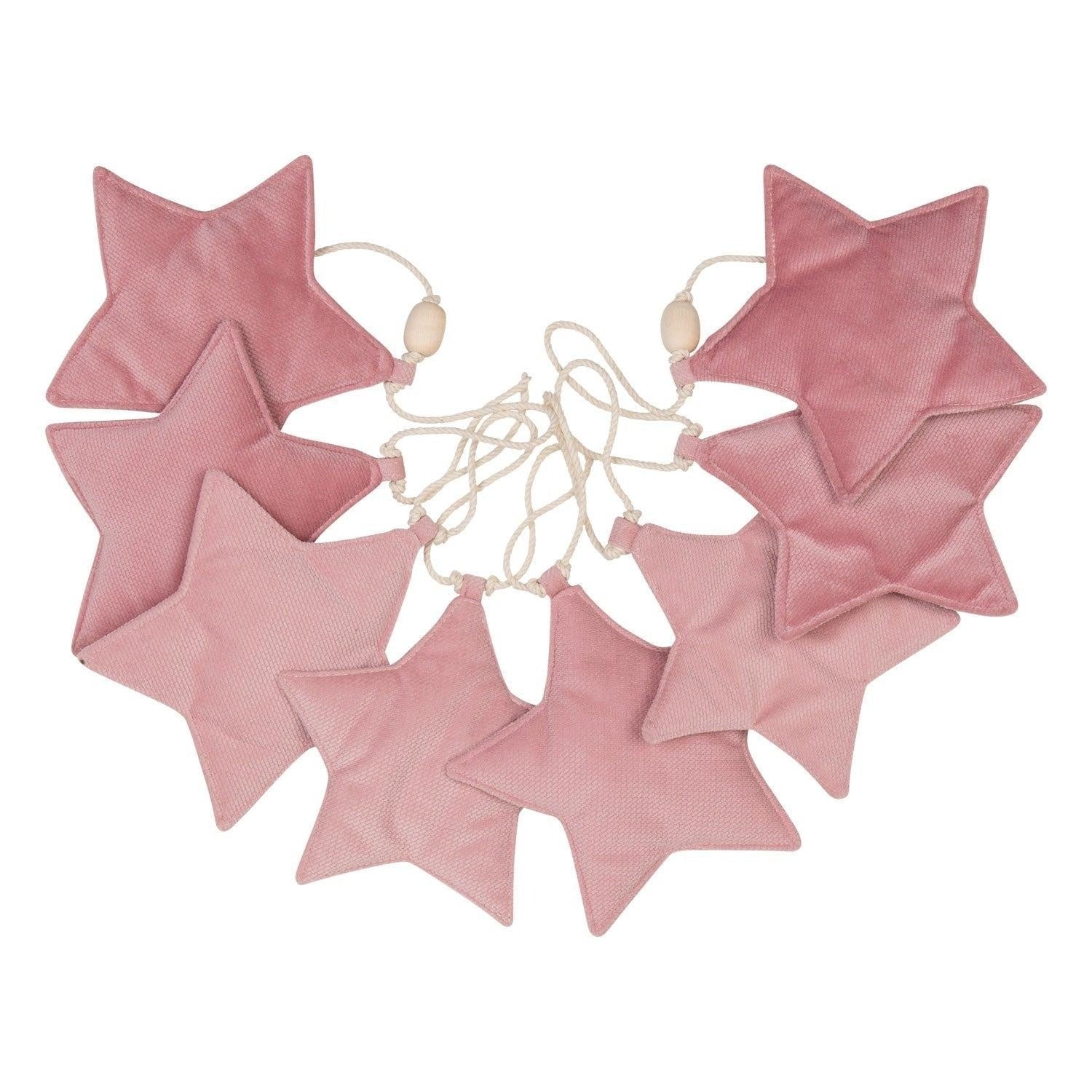 playful soft pink velvet star garland with wooden beads hanging over a whimsical nursery teepee