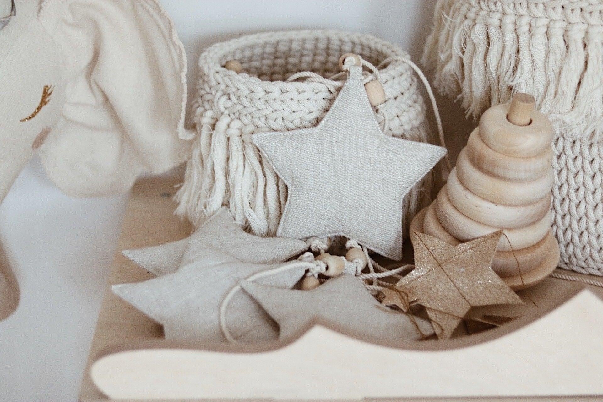 elegant sand star dust garland draped over a nursery window in soft morning light