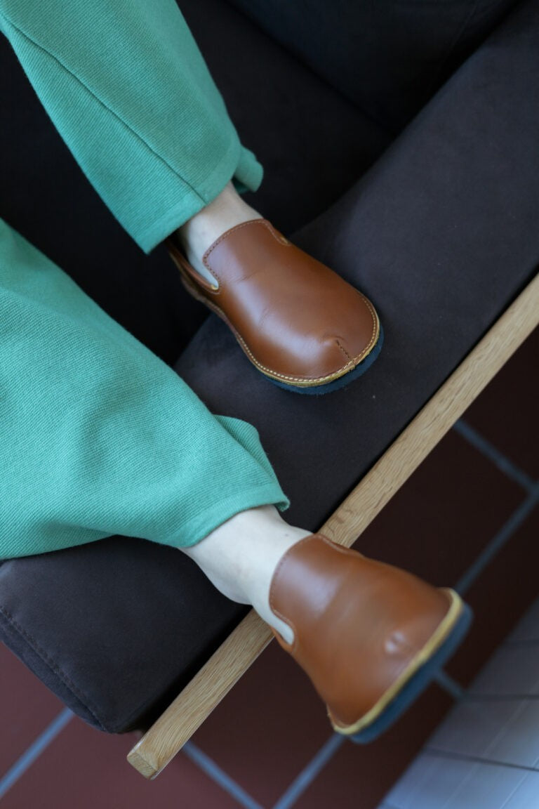 bold ocre leather loafers with cork insole, angled to show sleek silhouette and premium stitching